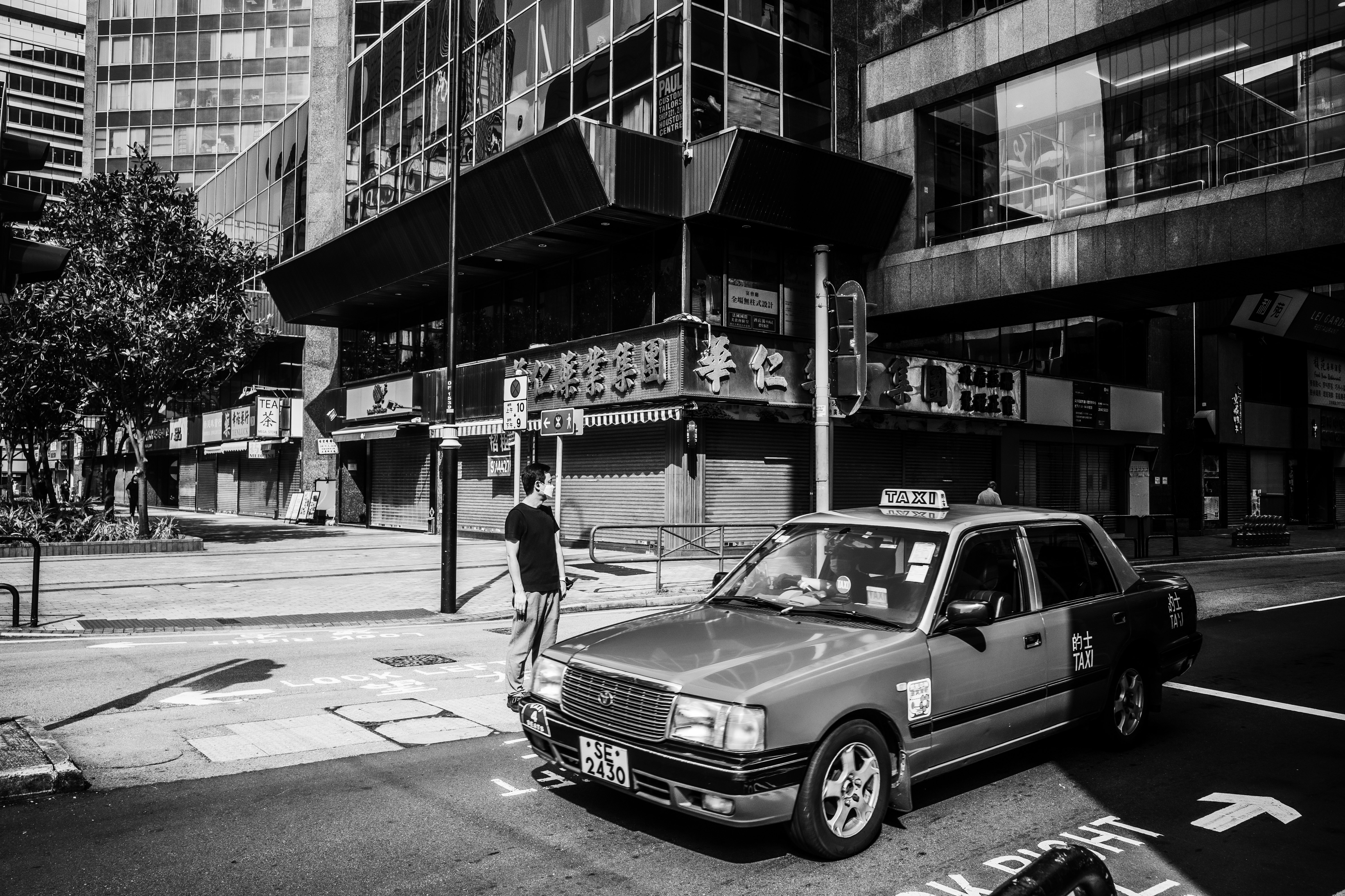 城市路口停着的经典轿车与行人