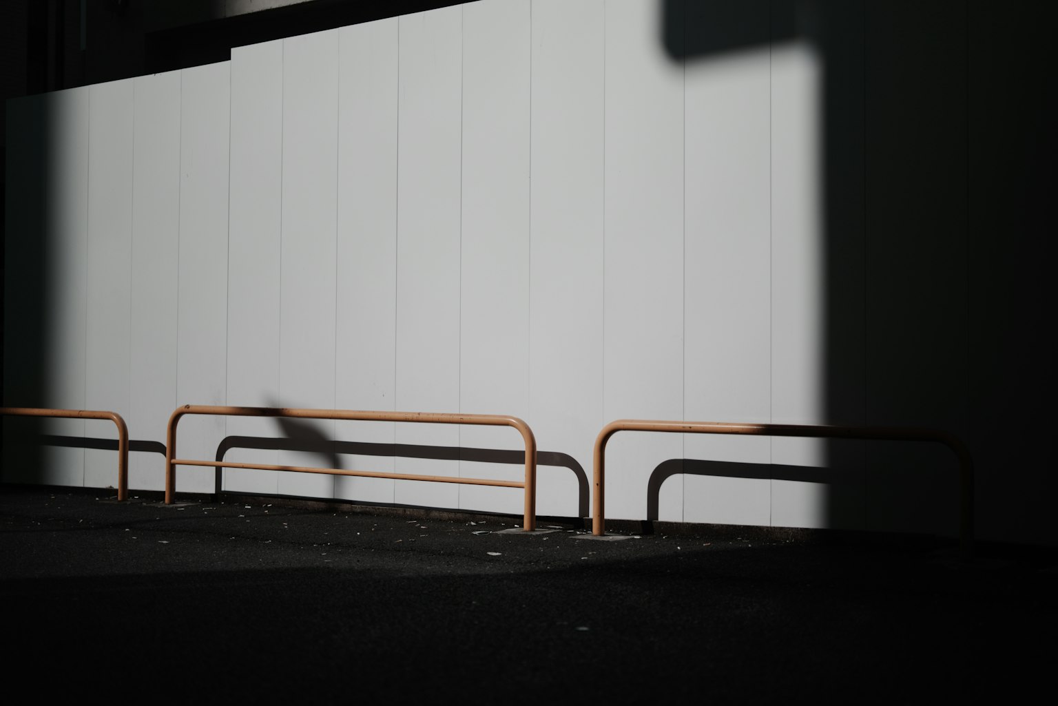 Urban scene featuring a white wall and contrasting shadows