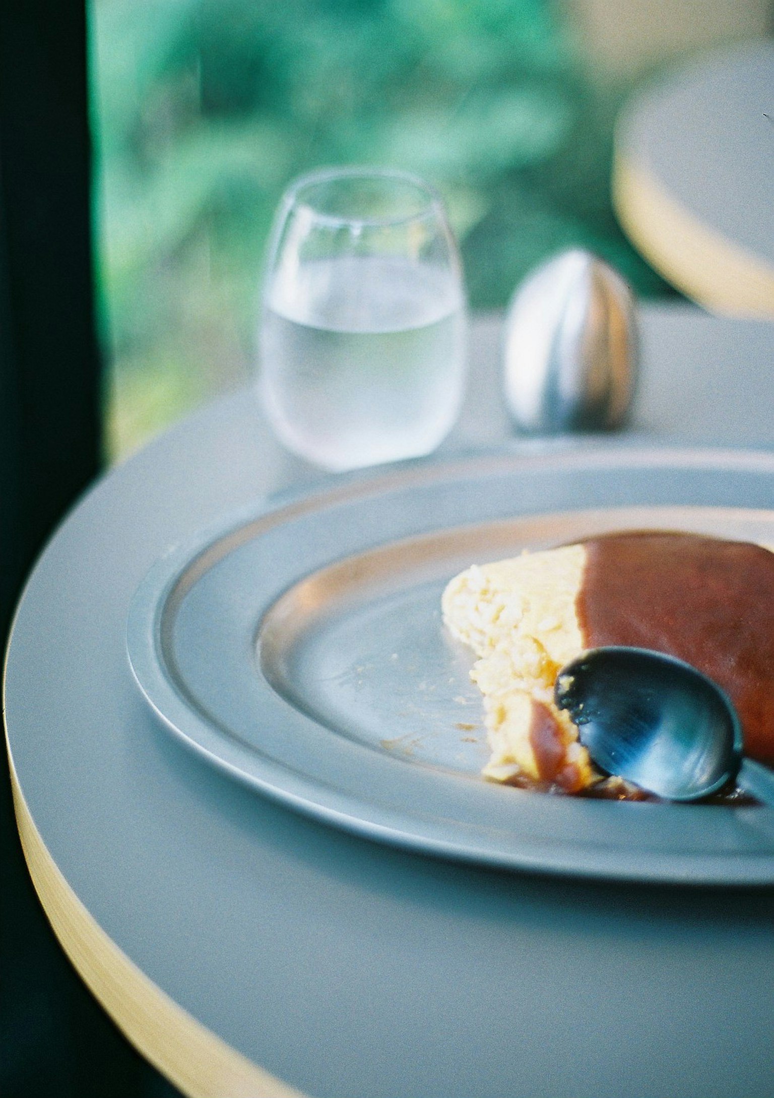 Bánh pancake soufflé trên đĩa bạc với một ly nước