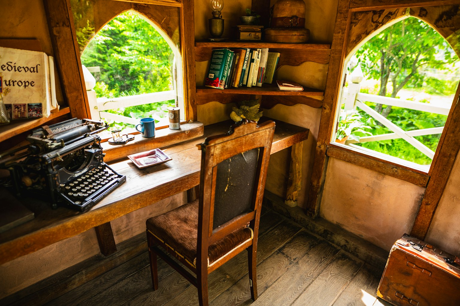 Espace de travail confortable avec un bureau en bois et une machine à écrire vintage vue sur le jardin