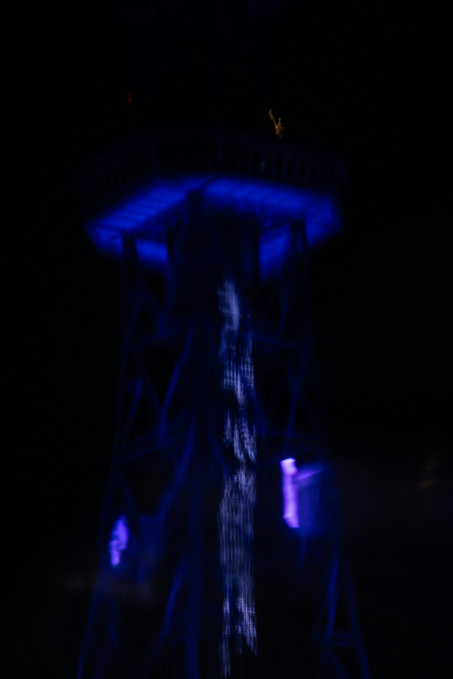 Image d'une tour éclairée par des lumières bleues la nuit