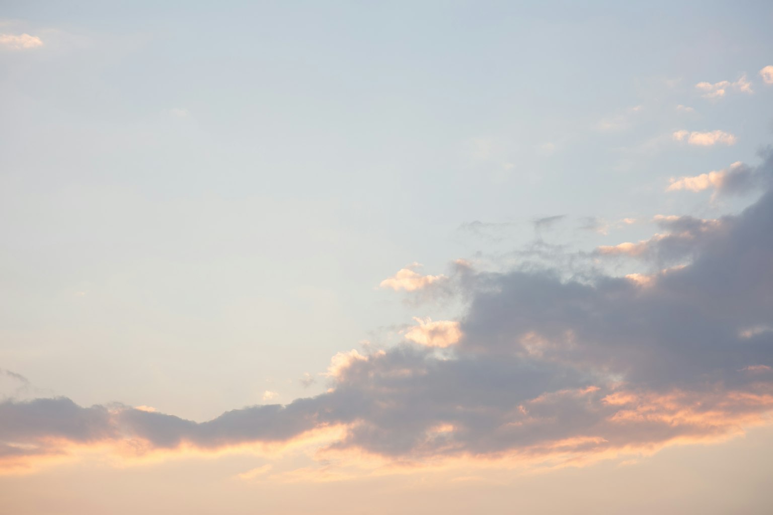 Nubes ligeras en un cielo azul con suaves tonos de atardecer