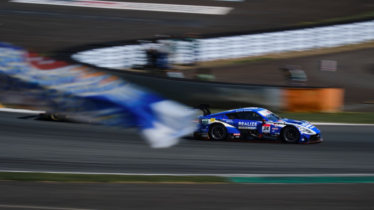 Une voiture de course bleue roulant sur le circuit