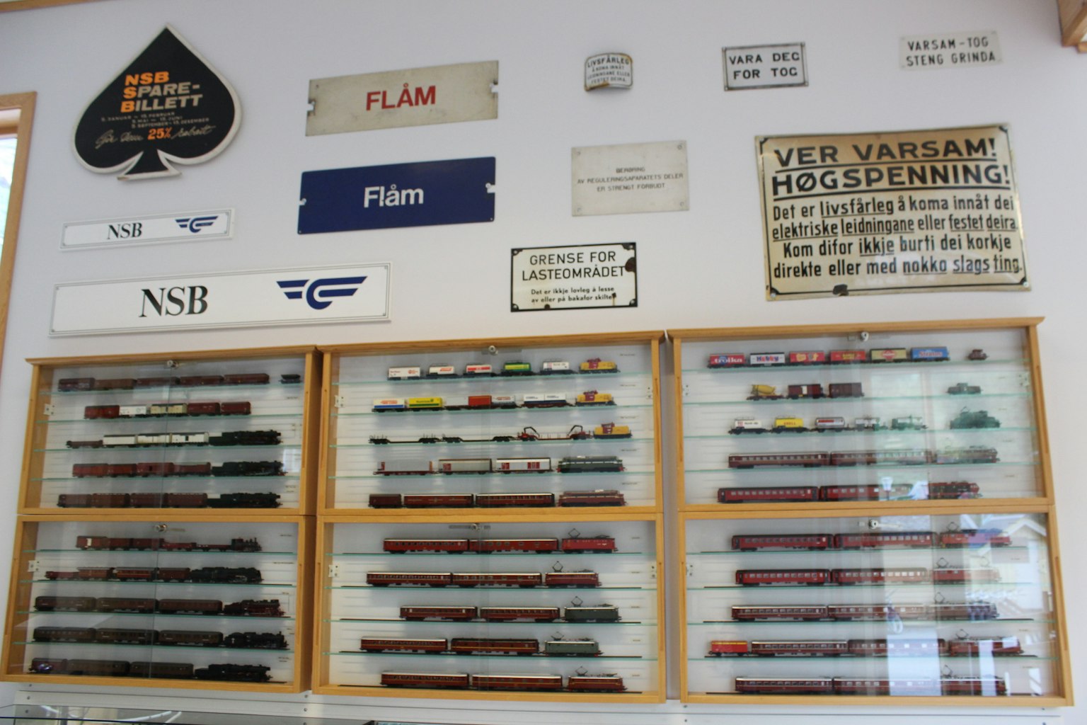 A display of model trains and various signs on a wall