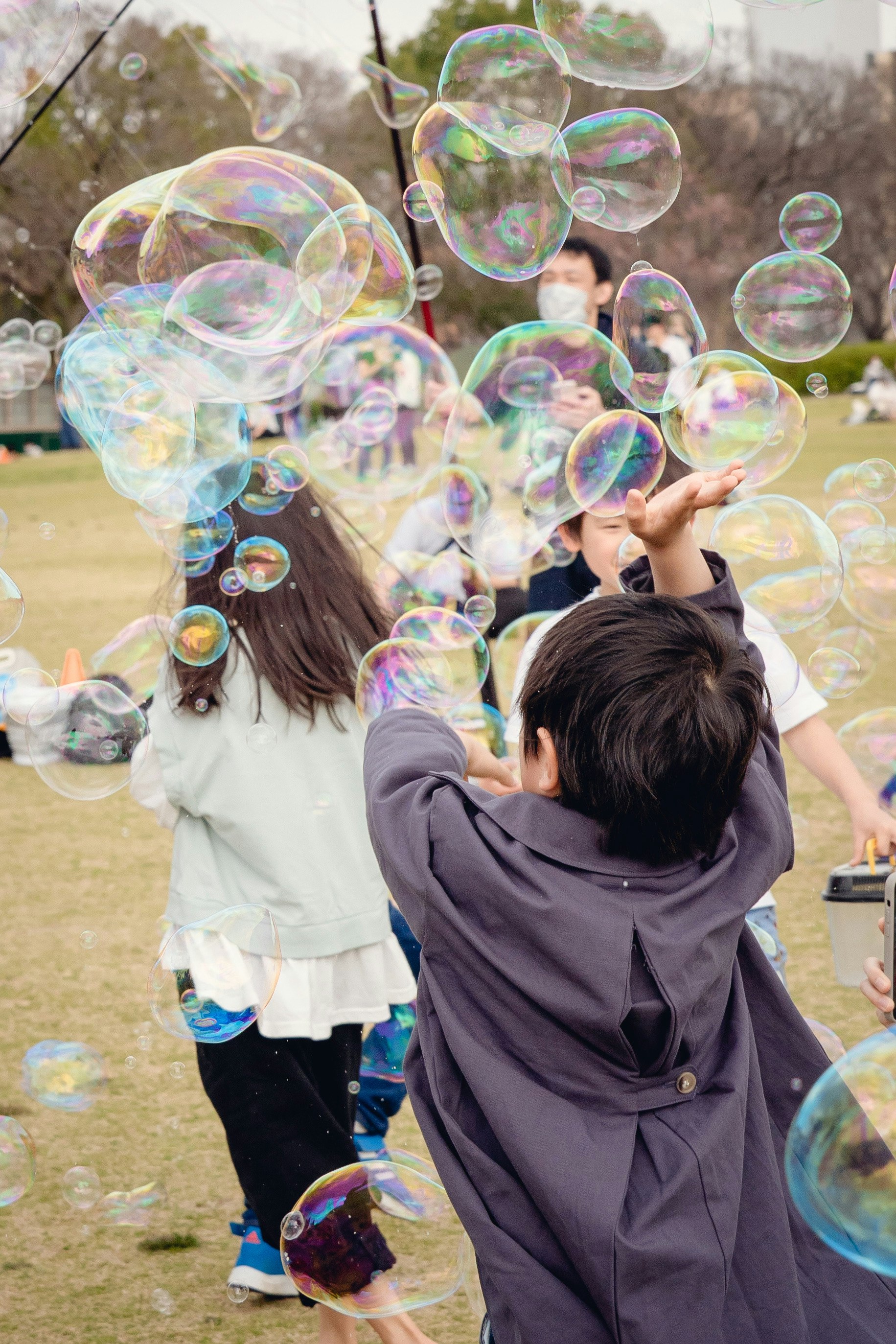 公園でシャボン玉を追いかける子どもたちの笑顔