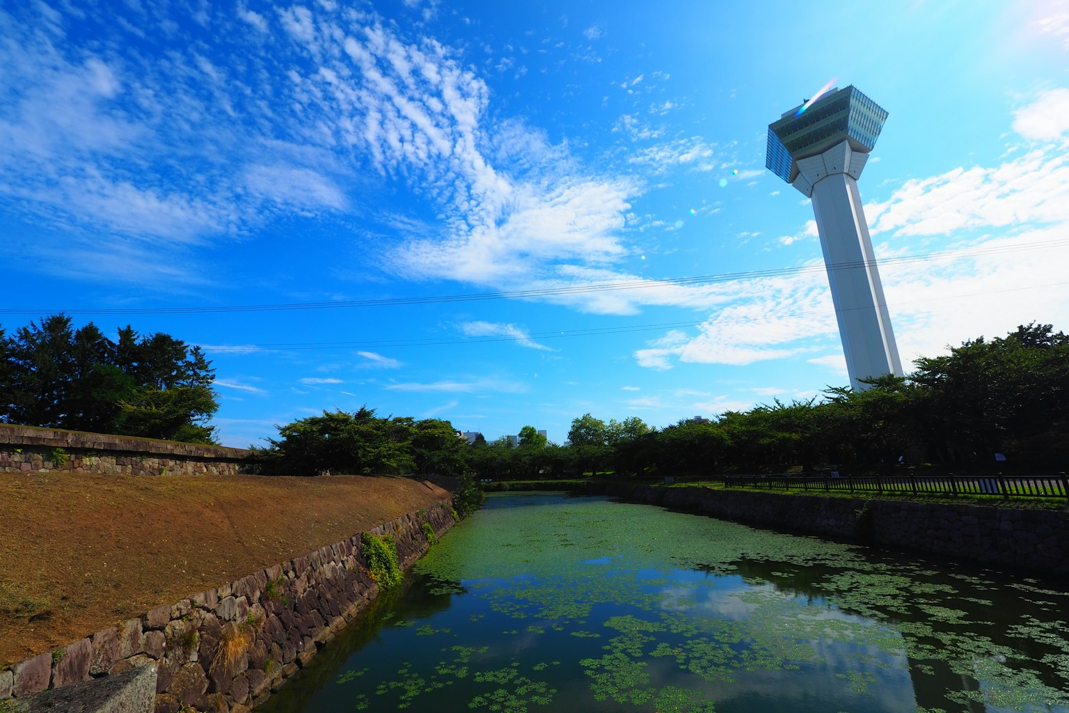 Malersiche Ansicht eines Gewässers mit einem hohen Turm unter einem blauen Himmel