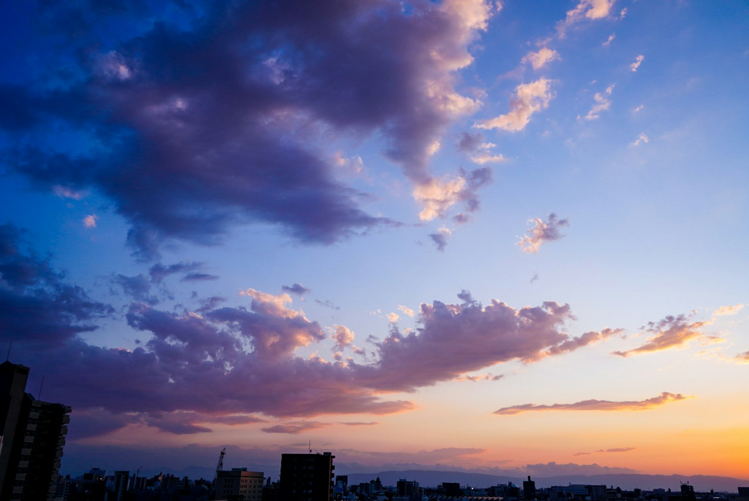 美麗的日落天空，雲朵和城市輪廓