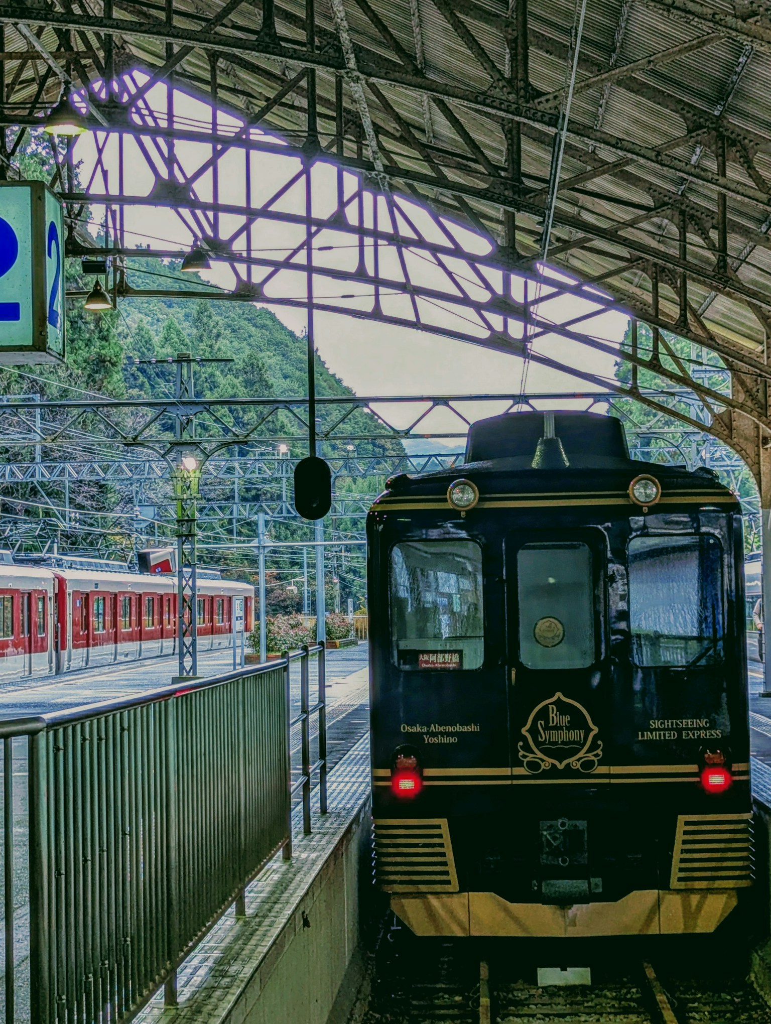 View of a black train and a red train at a train station