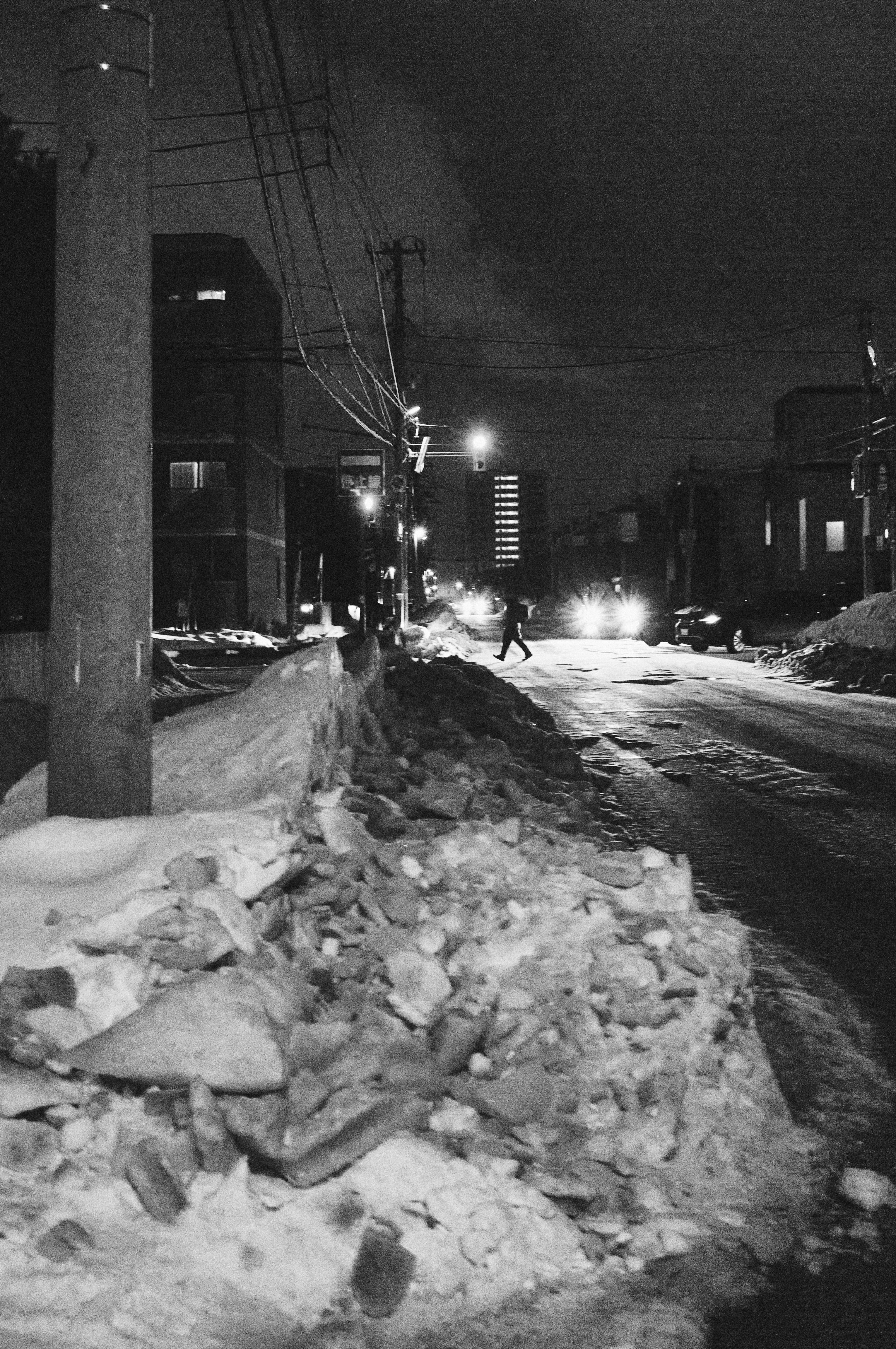 路灯照亮的夜晚小巷与残雪