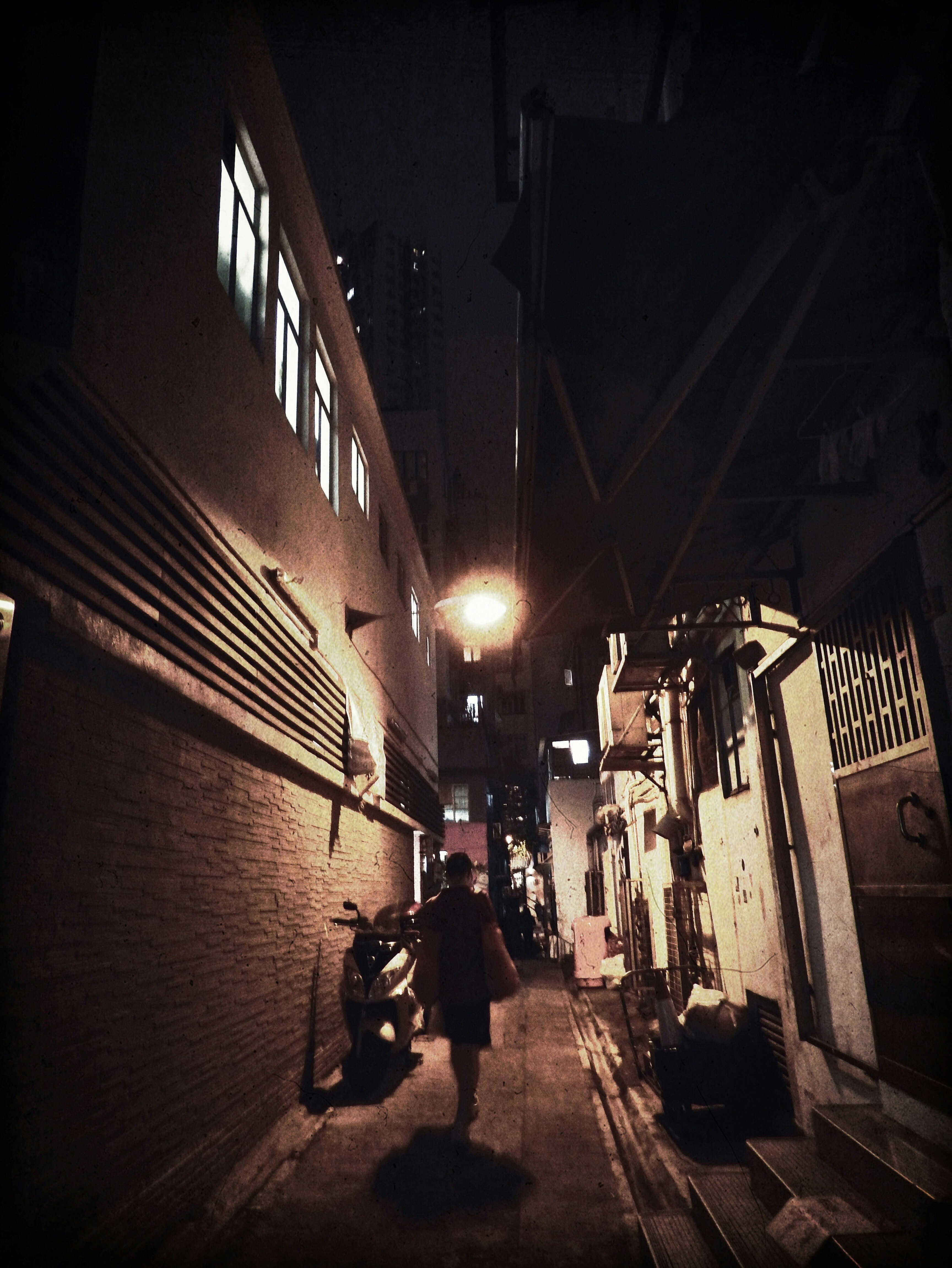 夜の路地に並ぶ壁と街灯のある商店街の通り