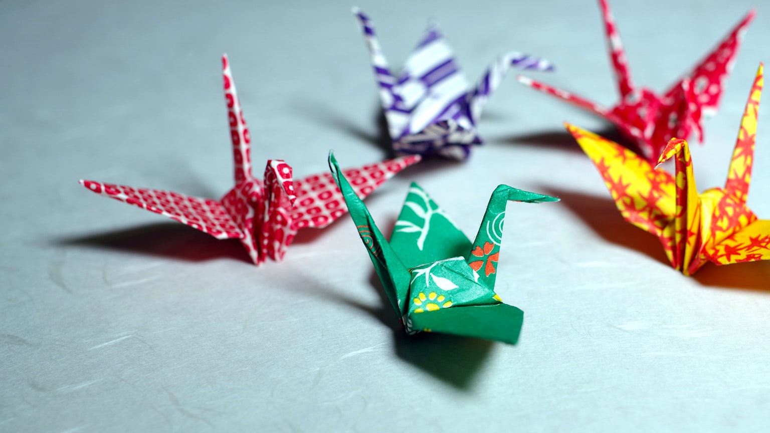 Grúas de origami coloridas dispuestas sobre una mesa
