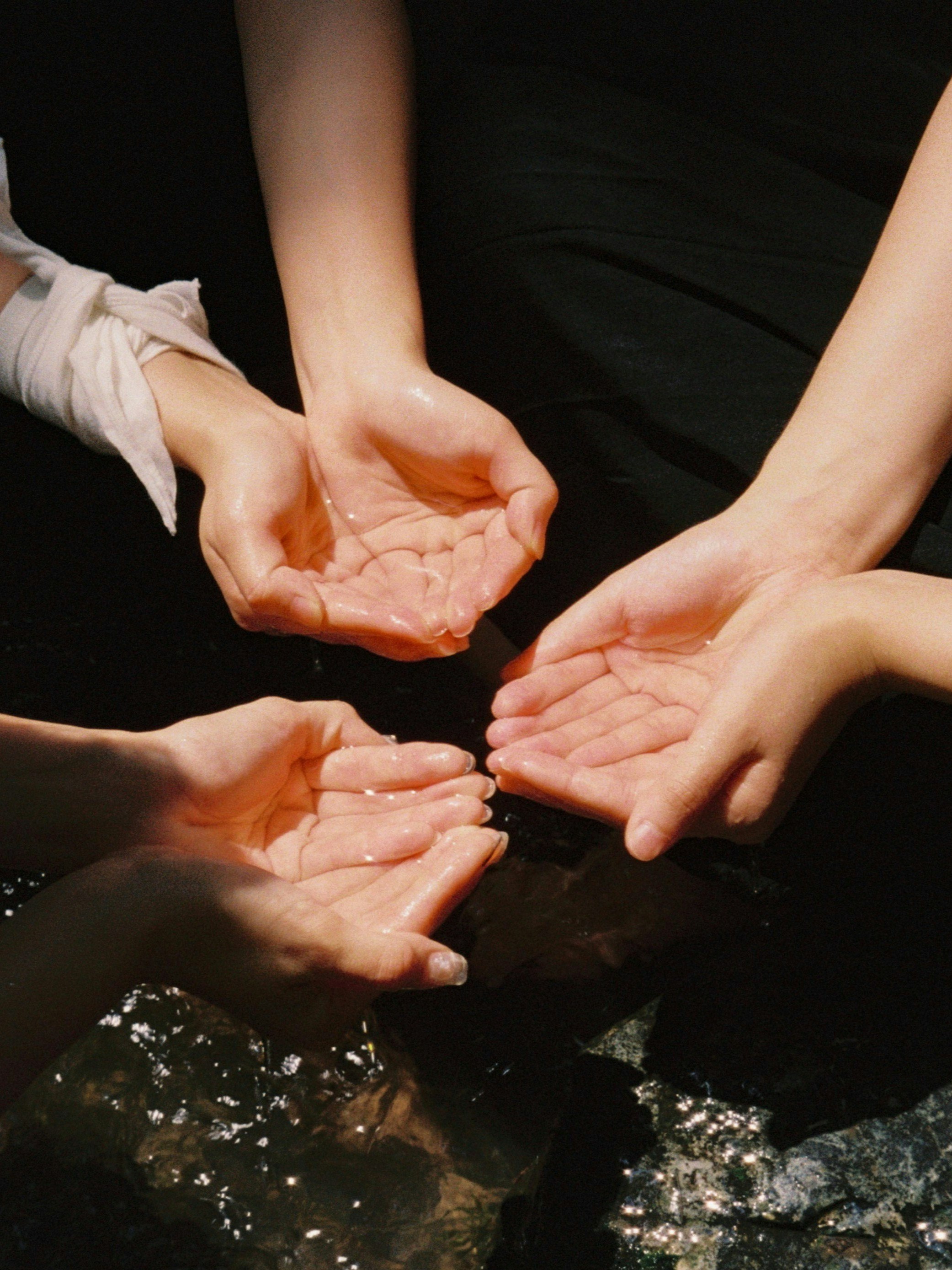 mani che versano e uniscono l’acqua dai palmi
