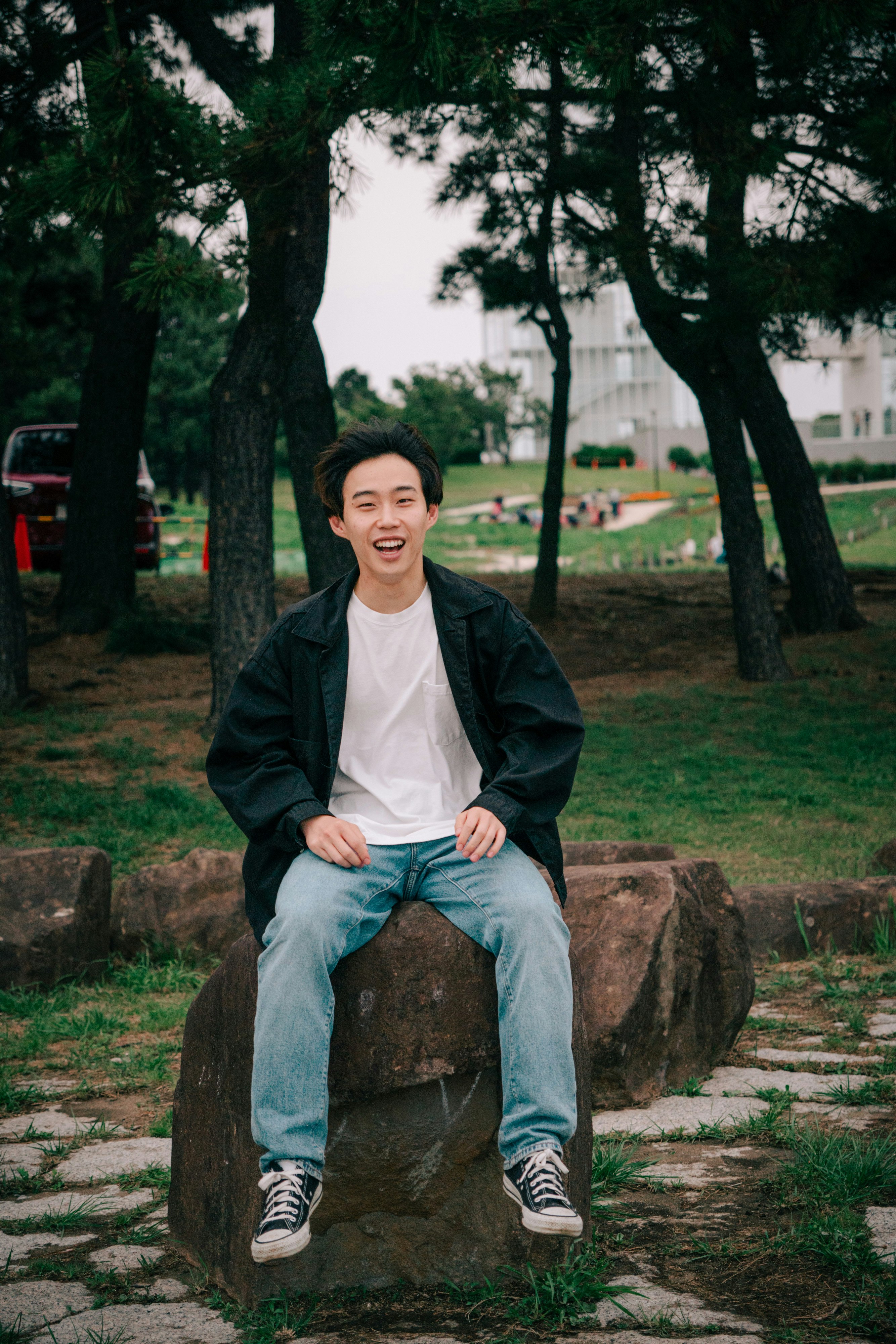 公園裡坐在樹樁上的男子