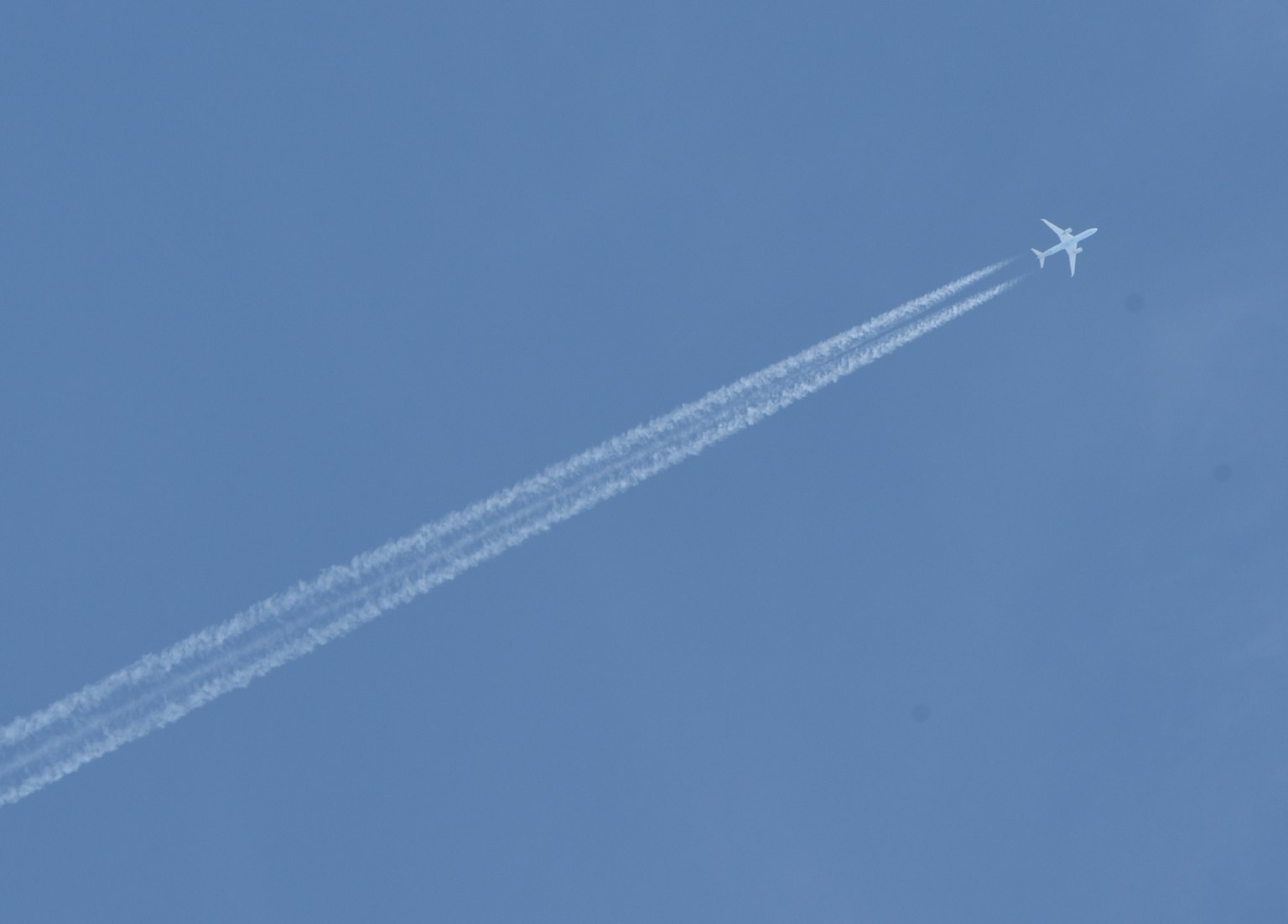 Avion volant dans un ciel bleu avec des traînées