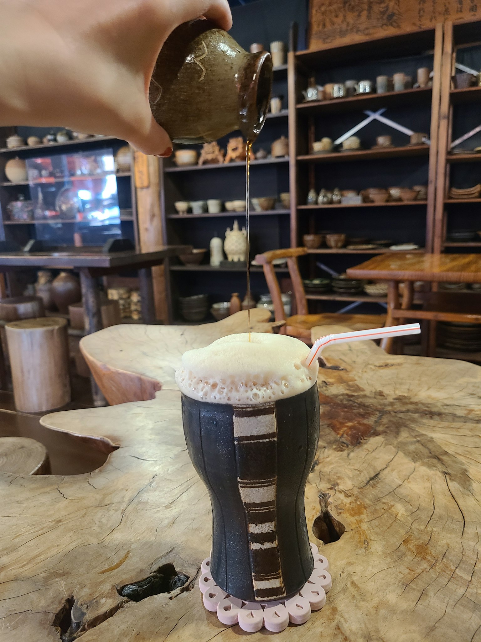 Gambar minuman yang dituangkan dari wadah dengan buih di atasnya