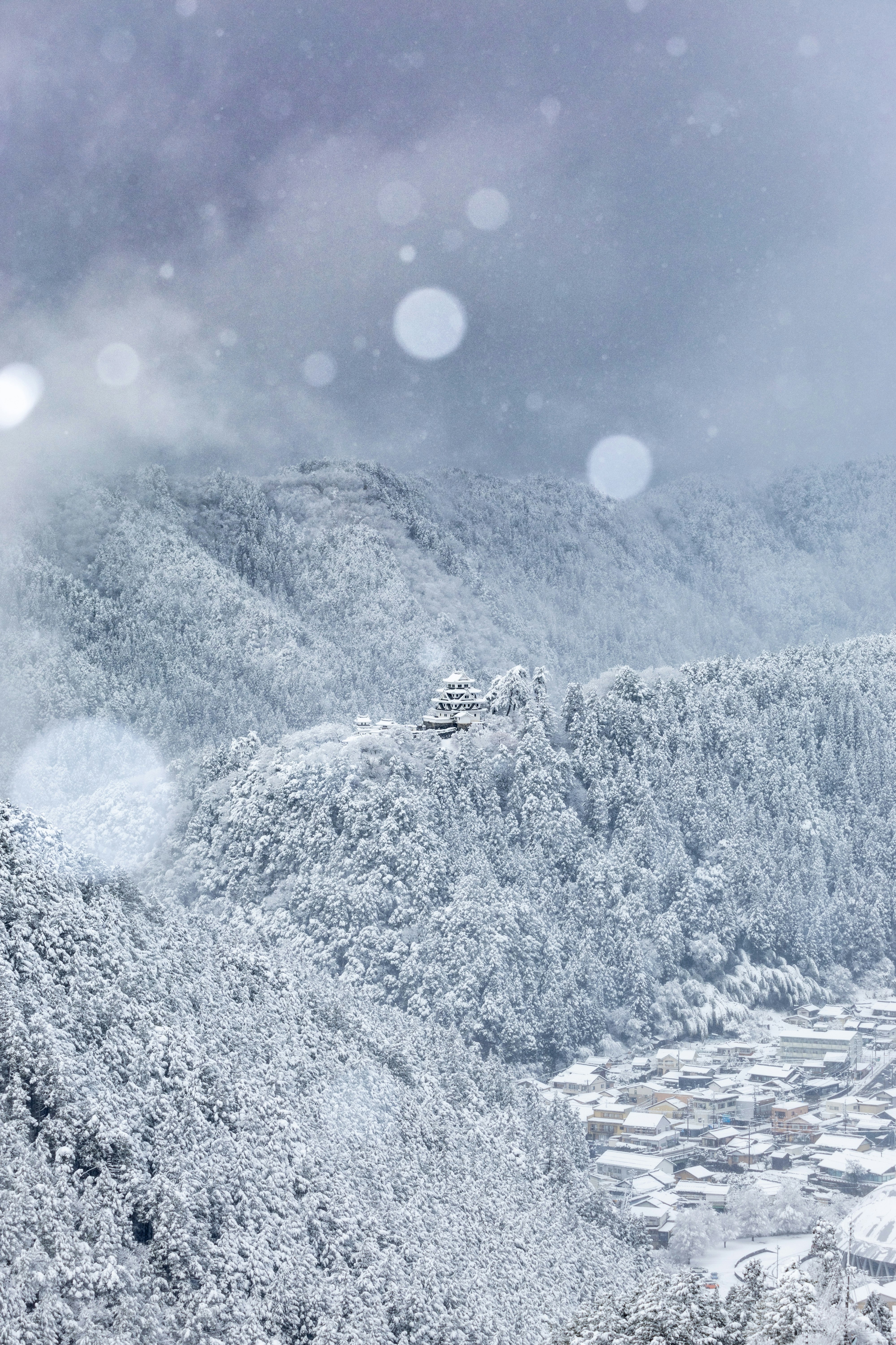 snow-covered mountain range with a small village settlement
