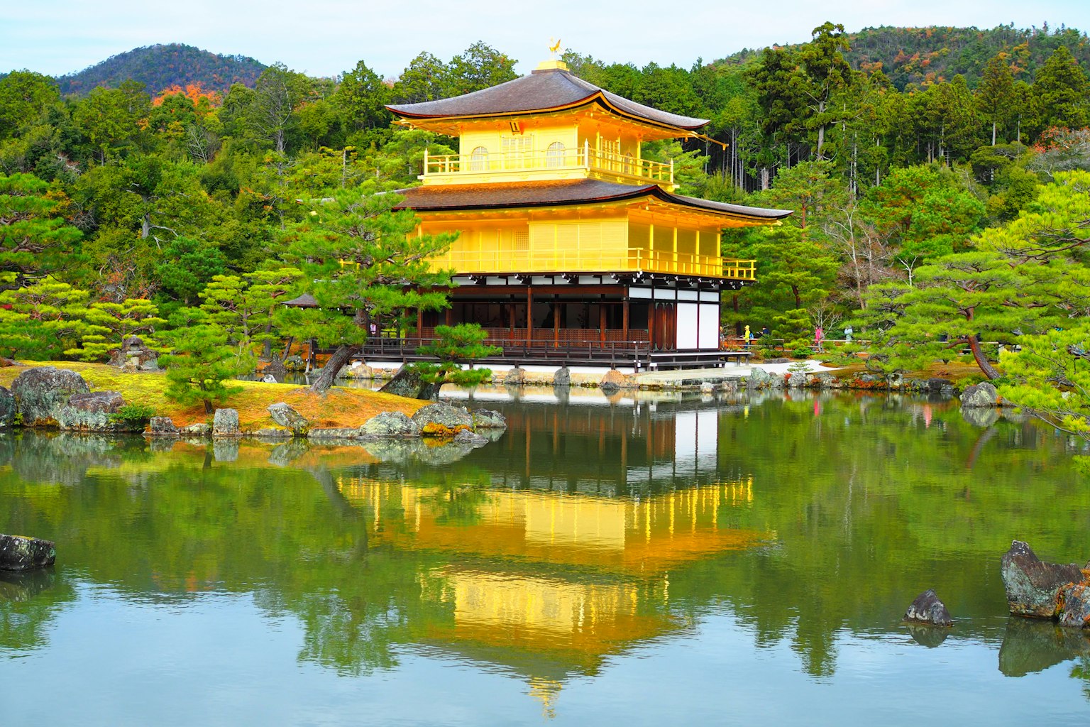 Kinkaku-ji che si riflette nello stagno sereno circondato da una vegetazione lussureggiante
