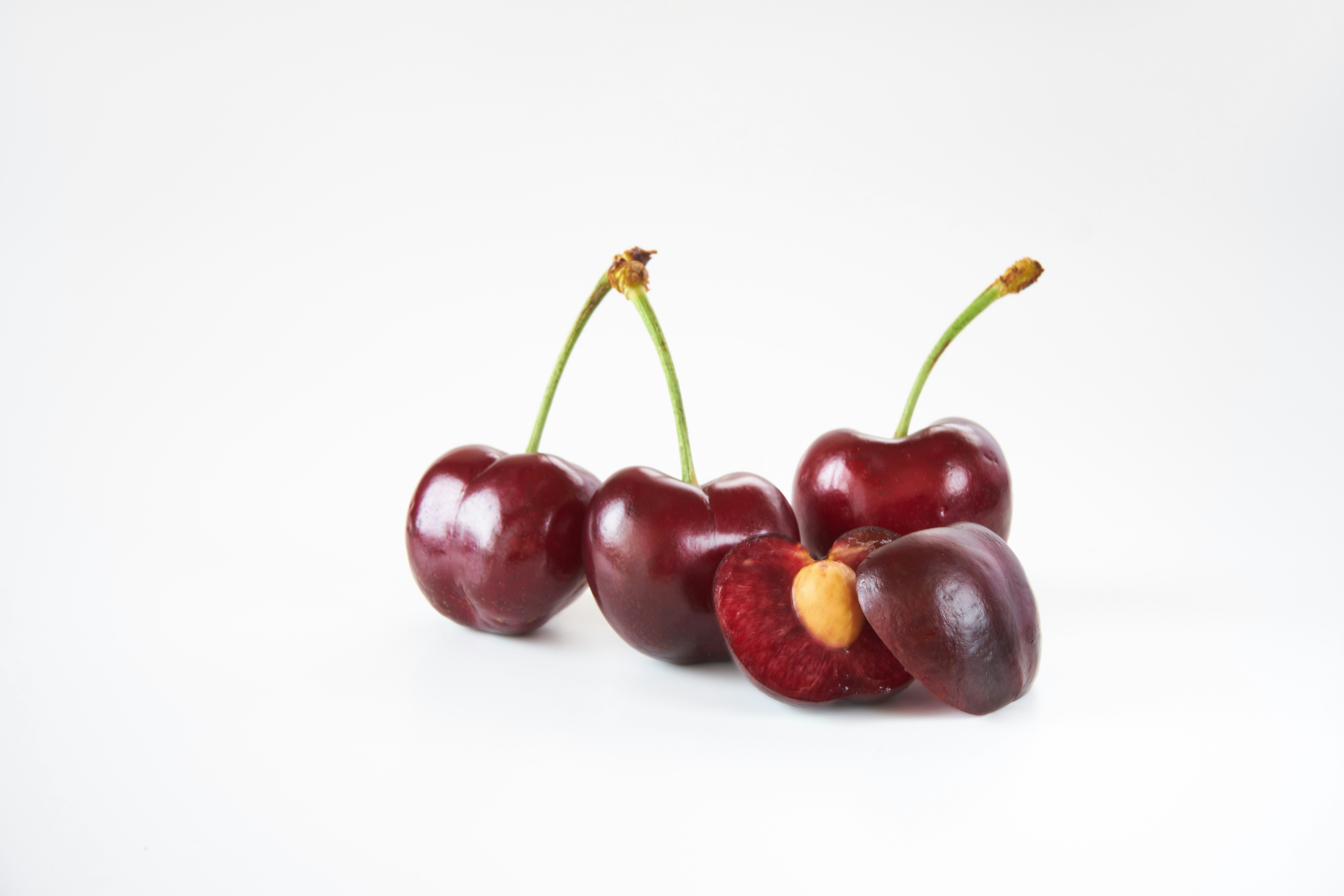 cerises rouges disposées sur fond blanc