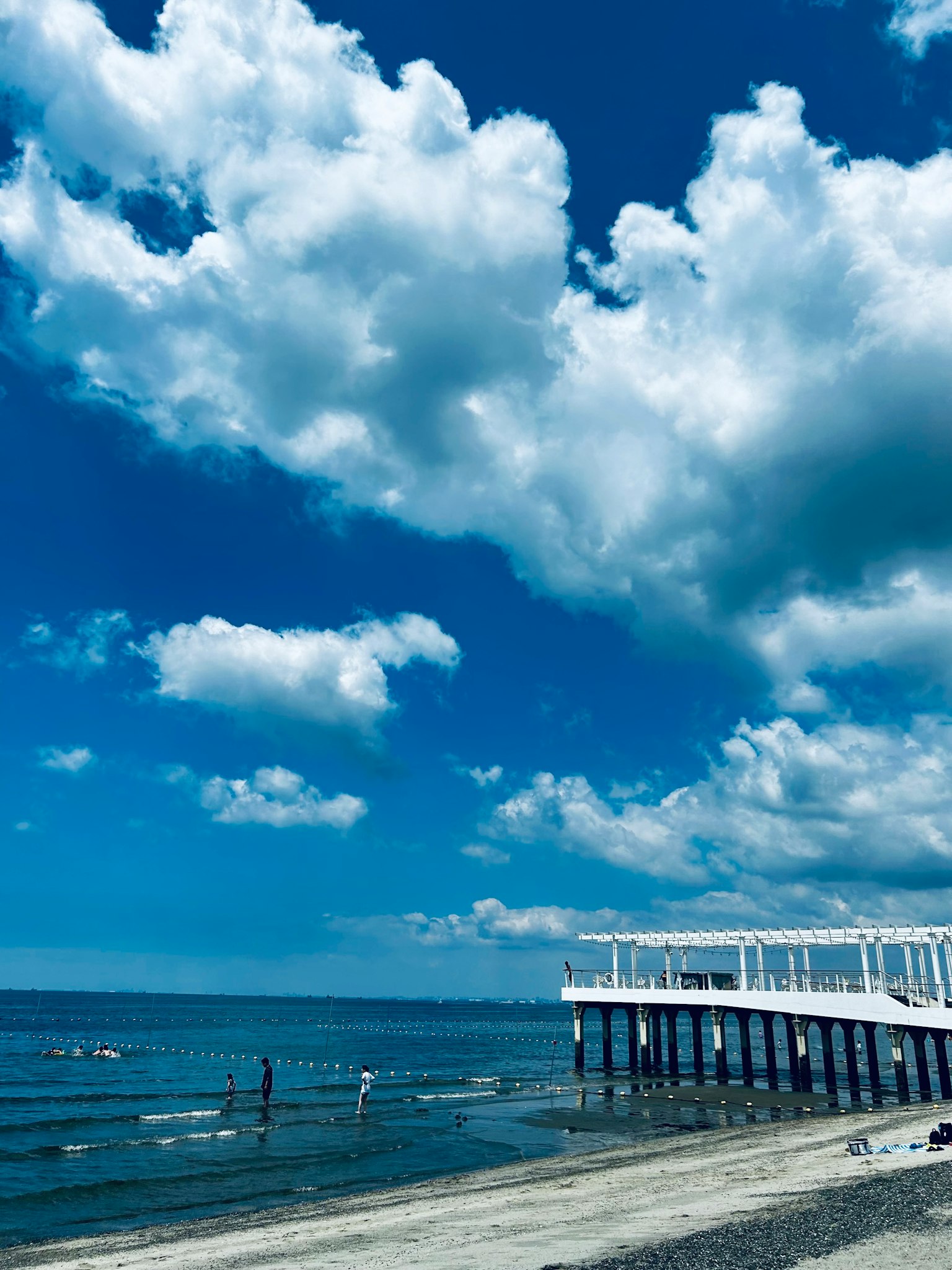 海岸風景，藍天和白雲，木栈橋延伸至水面