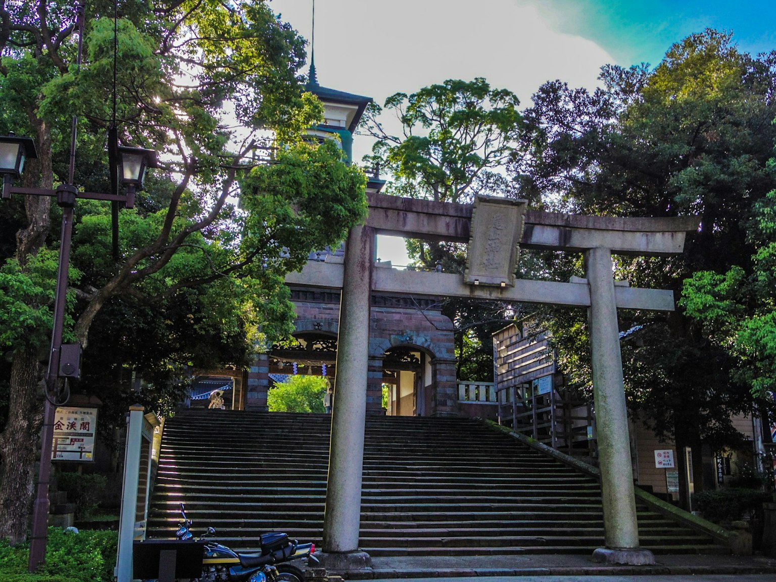Puerta torii rodeada de vegetación con escaleras