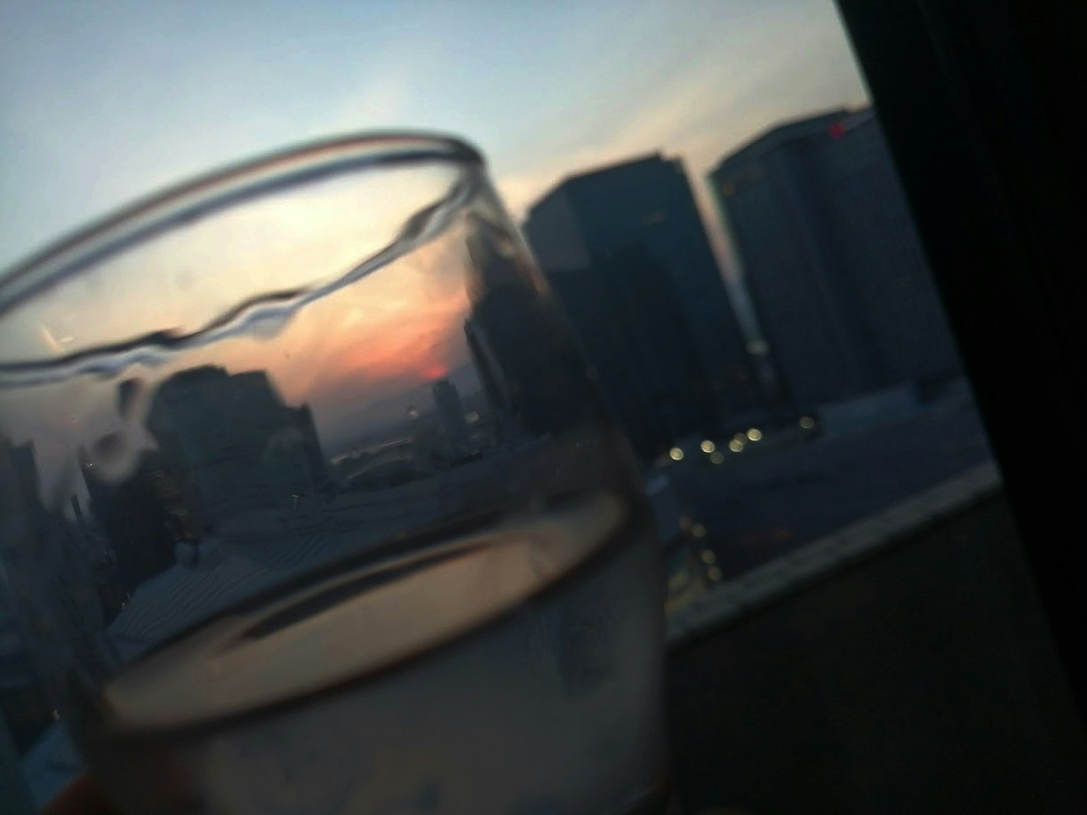 透明水杯与日落背景和建筑轮廓