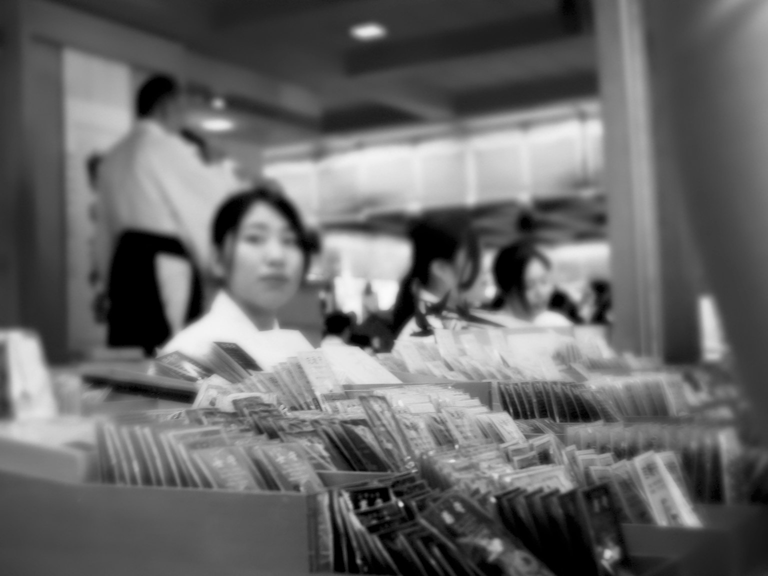 Black and white photo featuring files in the foreground with people in the background