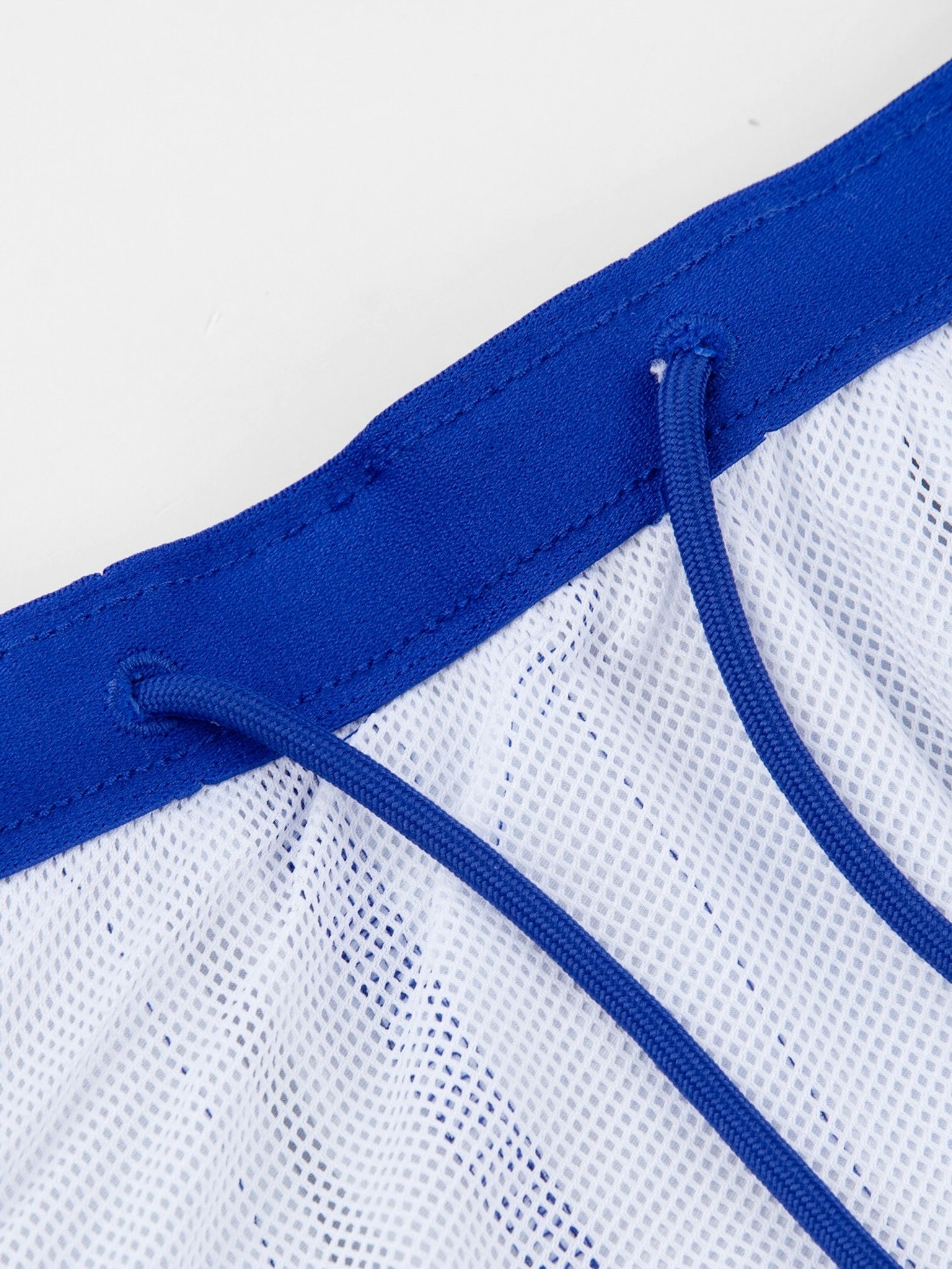 Close-up of white mesh fabric with blue drawstring