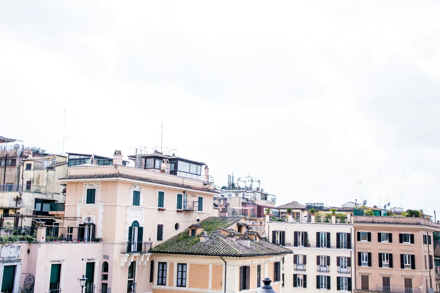 Khung cảnh thành phố Rome với các tòa nhà màu pastel dưới bầu trời nhiều mây