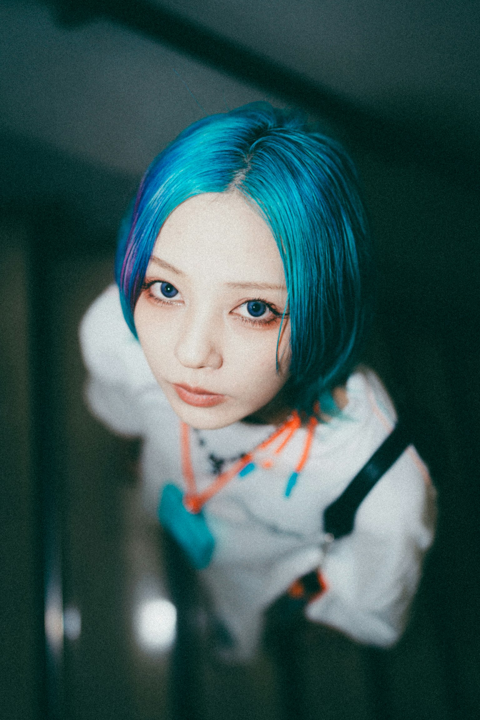 A woman with blue hair looking up the stairs