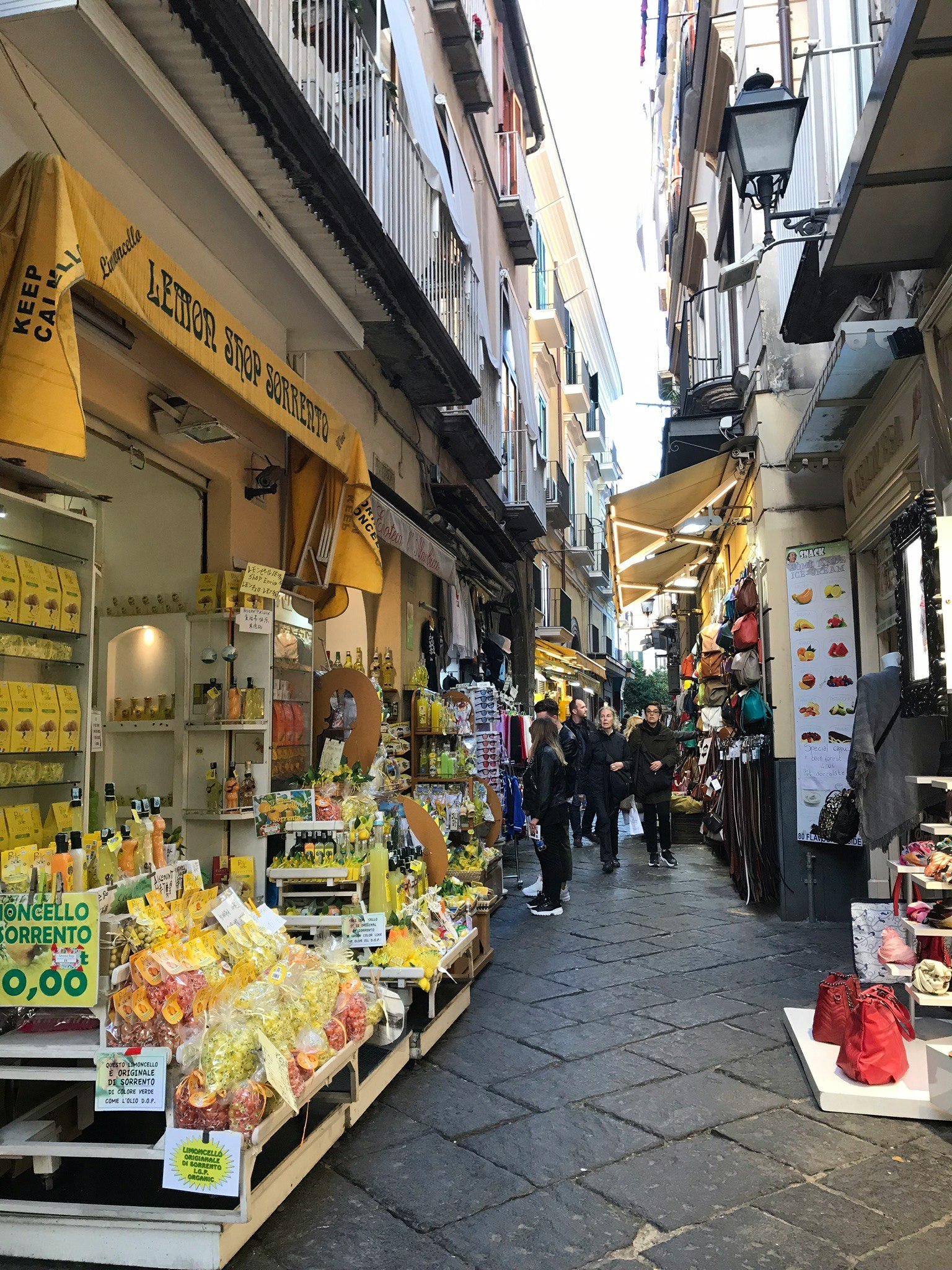 Jalan sempit yang dipenuhi toko buah dan lemon dengan orang-orang yang ramai