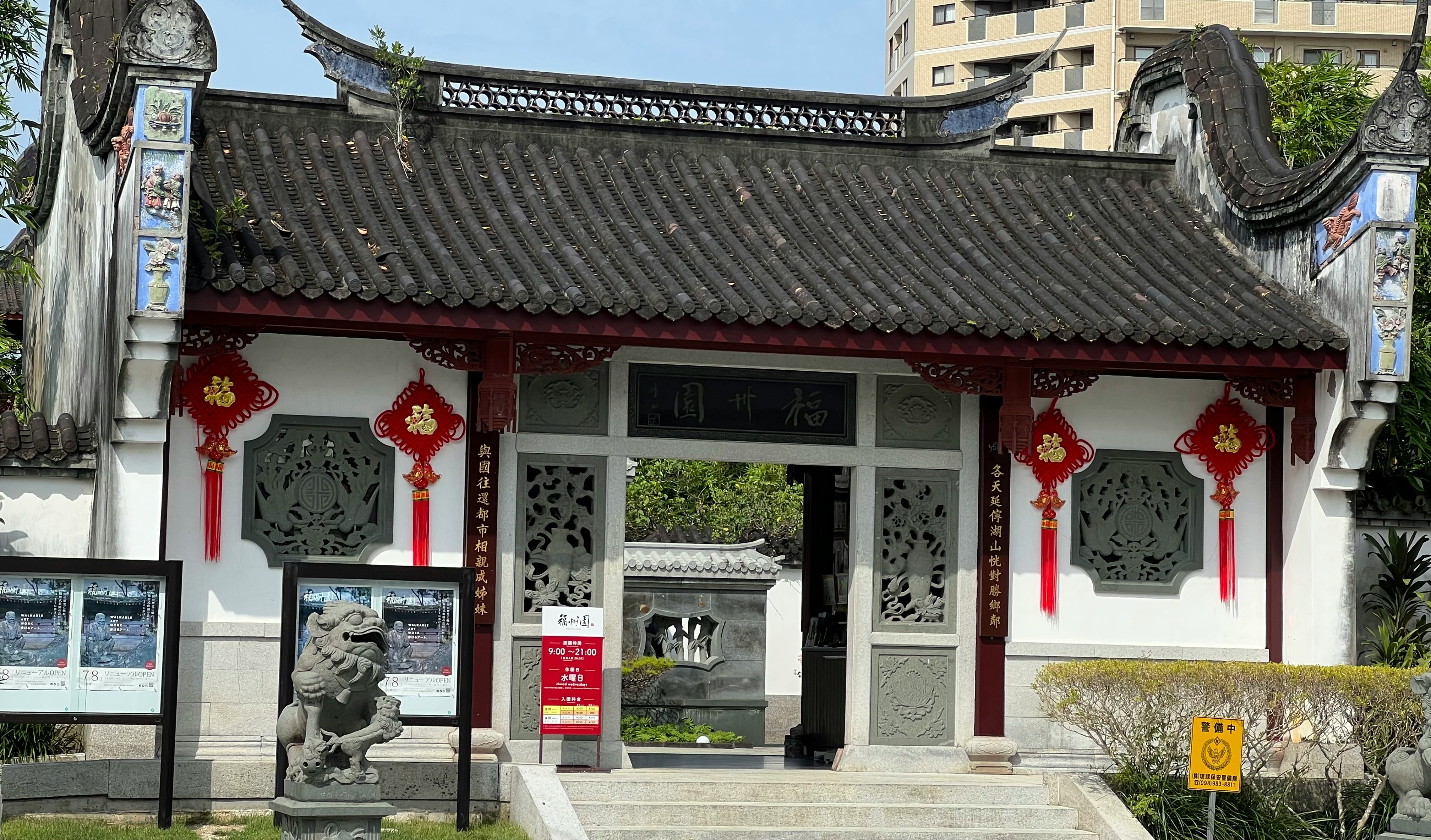 entrada de un templo con puerta tradicional y esculturas de piedra en el patio