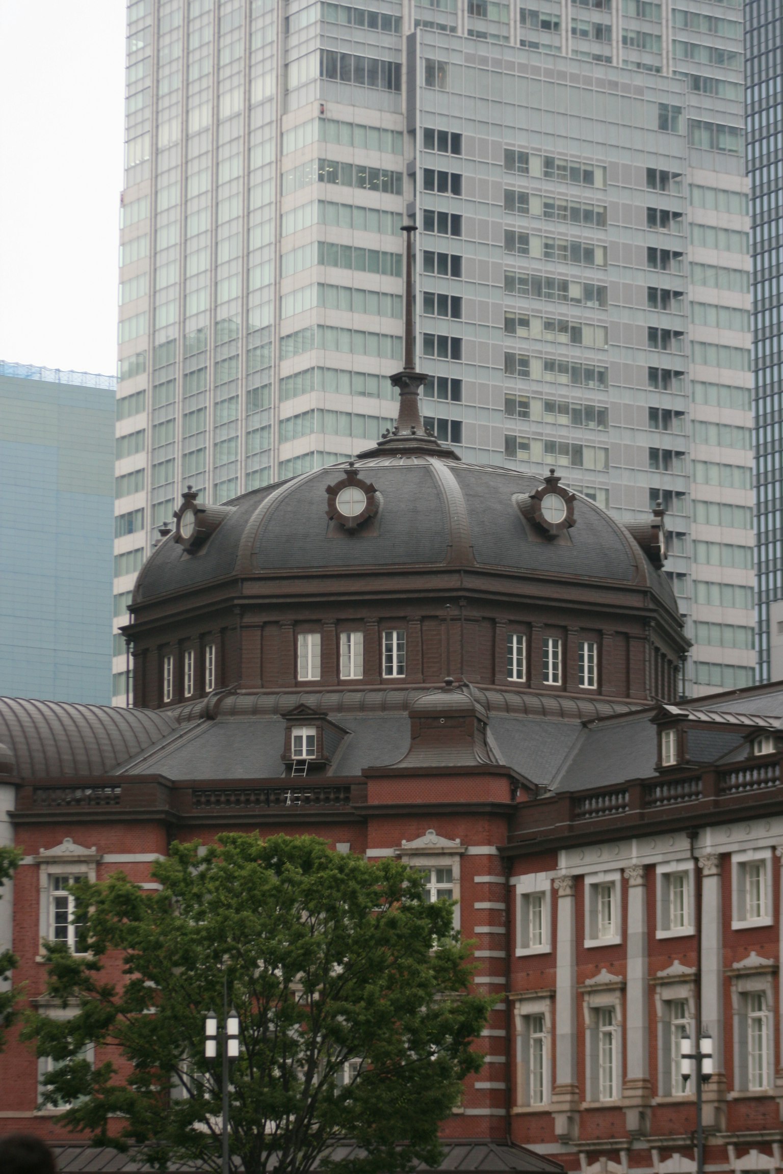Contrasto tra l'edificio storico della stazione di Tokyo e i grattacieli moderni