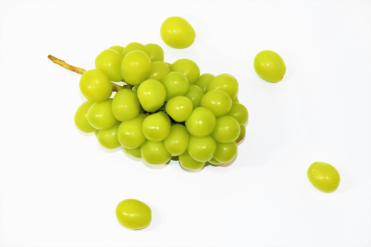 A cluster of green grapes on a white background