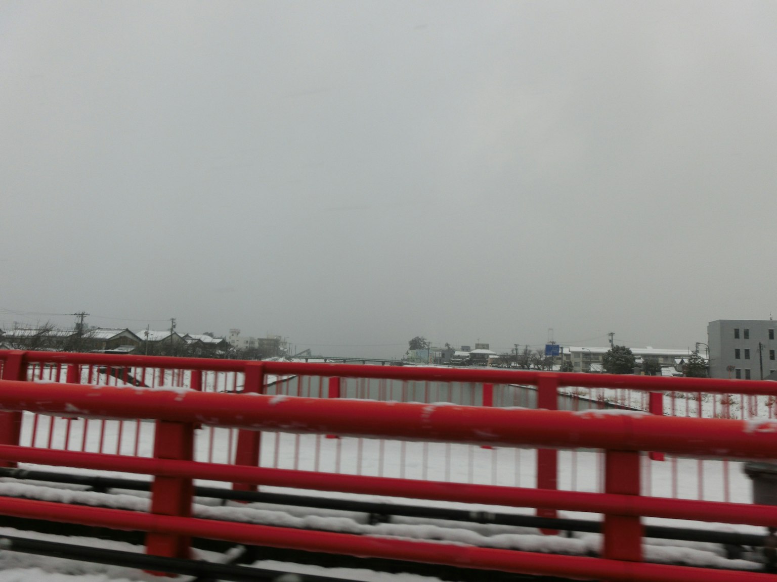 雪覆盖的景观和红色桥梁在阴天