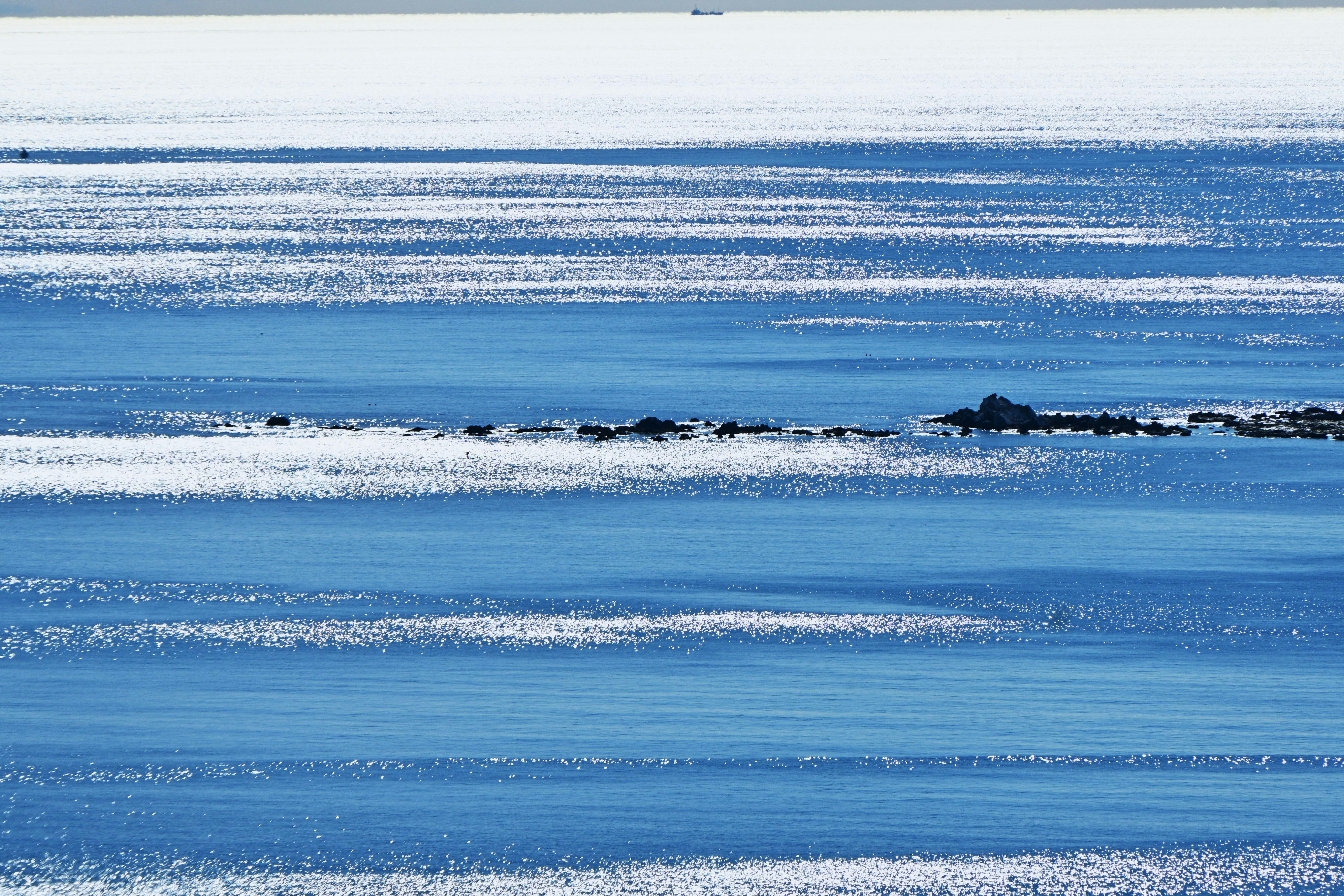 凪いだ海面の水平線と波のきらめき