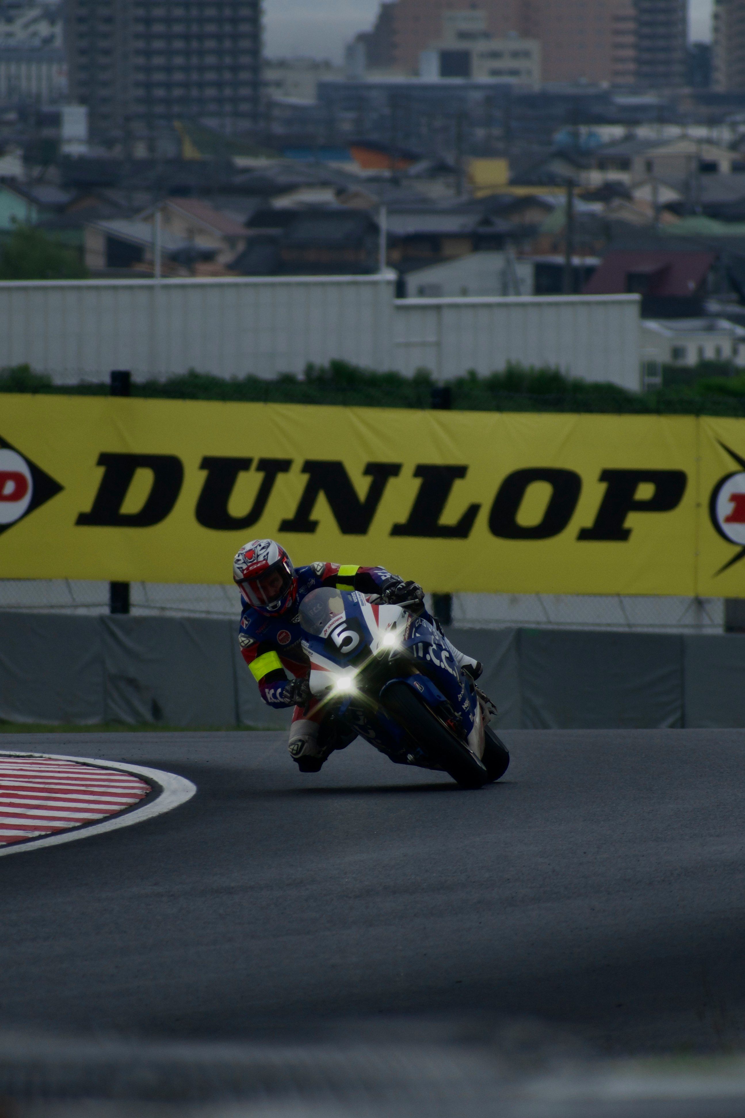 厚い雲の下でライト点灯のバイクがゴールを目指す鈴鹿サーキット