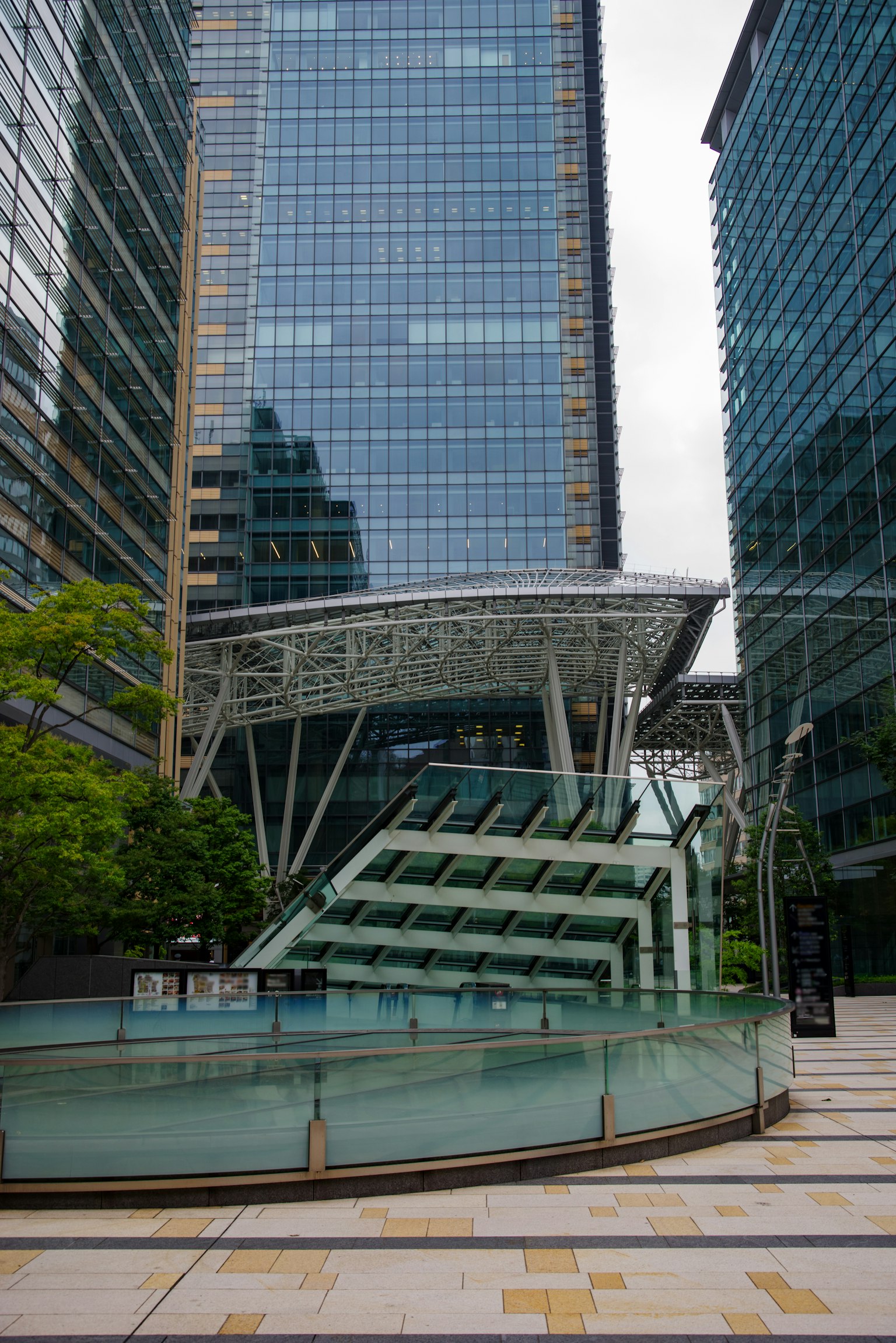 Pemandangan gedung pencakar langit modern dengan fasad kaca mengelilingi fitur air