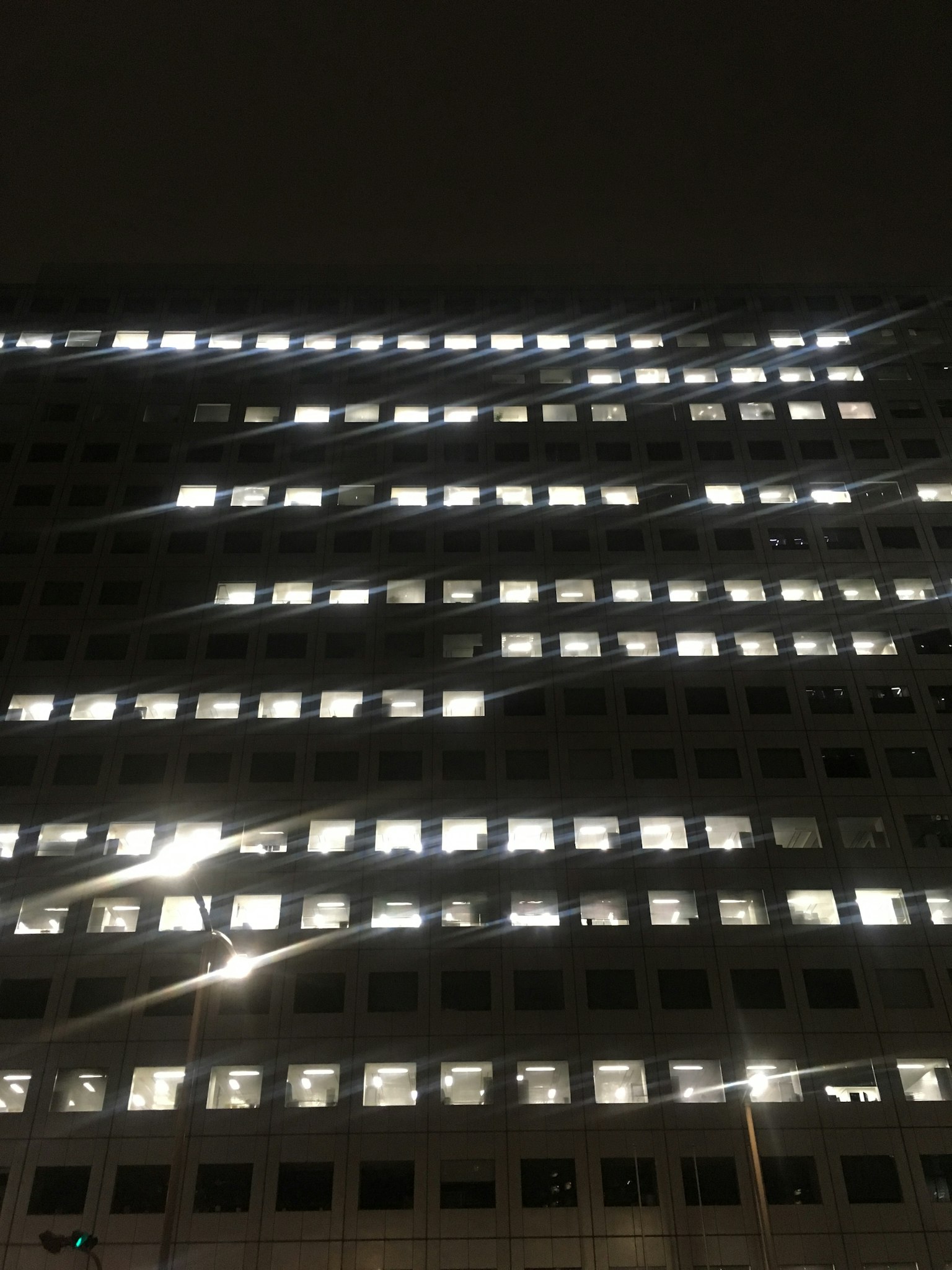 Vista notturna di un edificio con motivi di finestre illuminate distintive