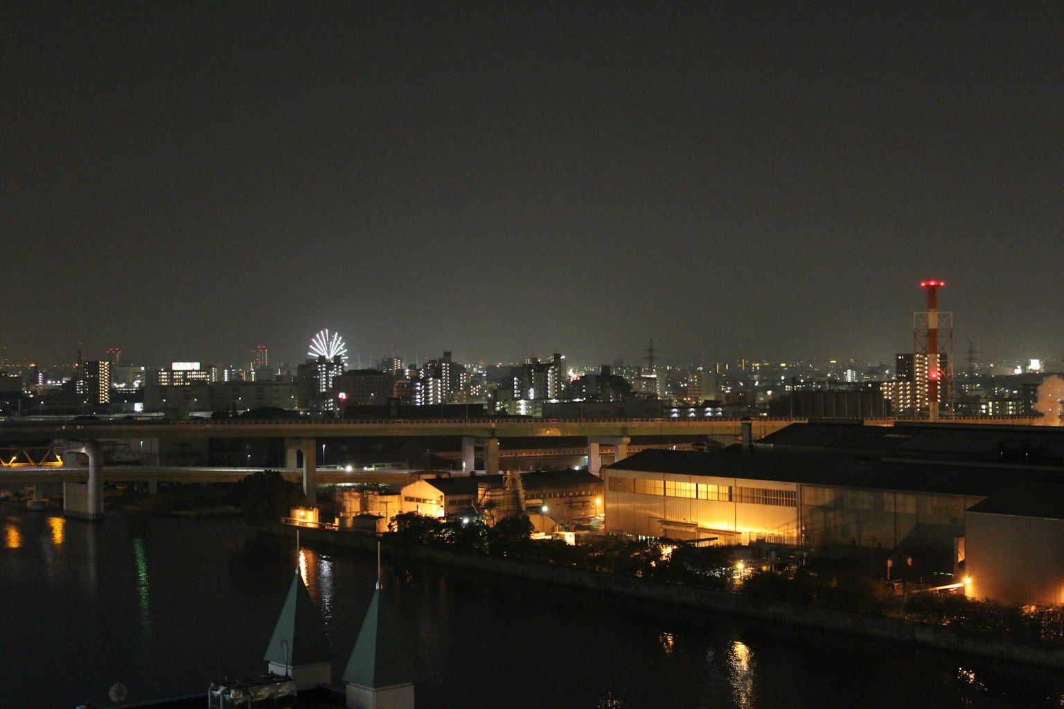 Paesaggio urbano notturno con edifici illuminati e un ponte