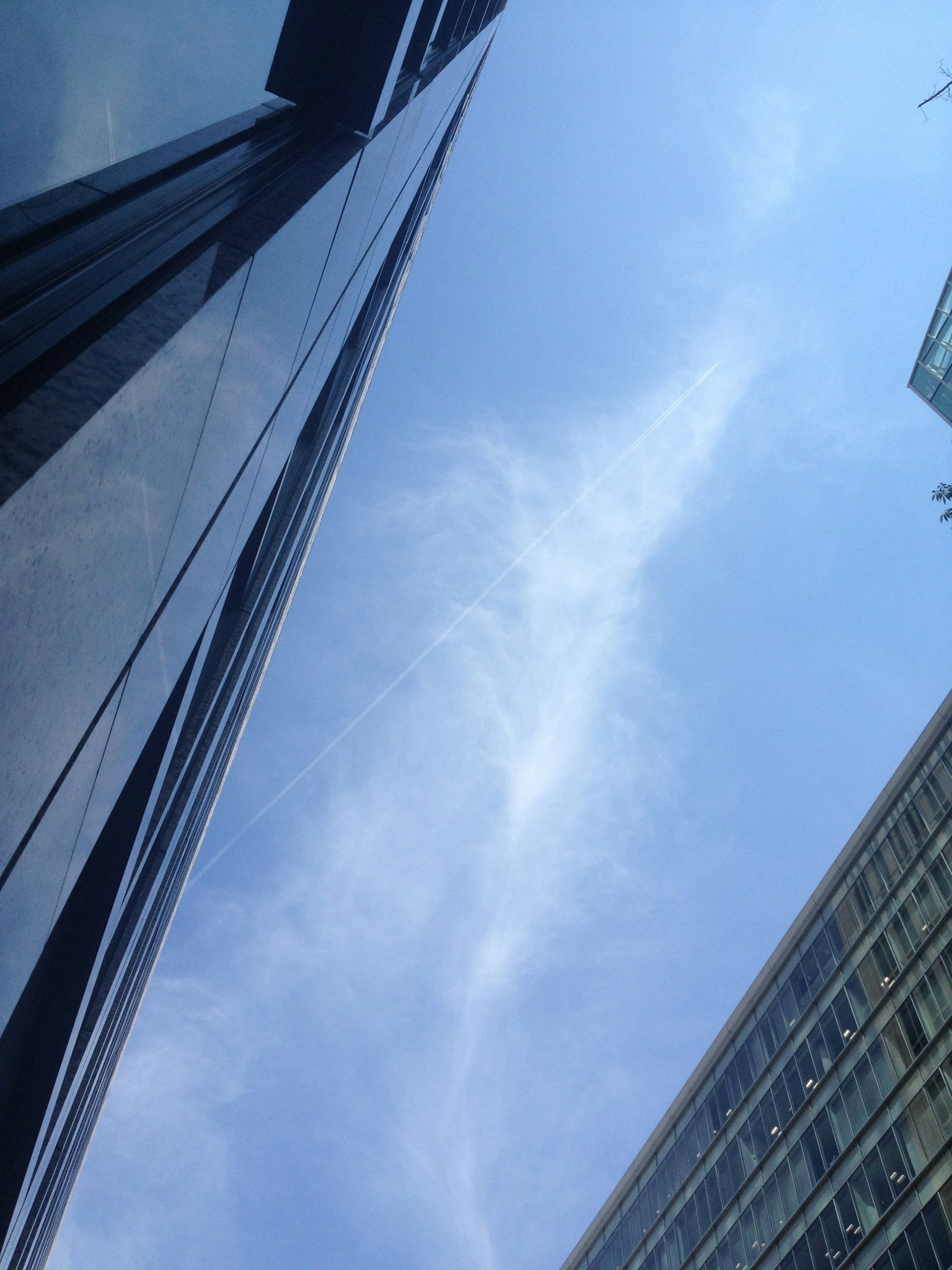 View of blue sky and clouds between skyscrapers