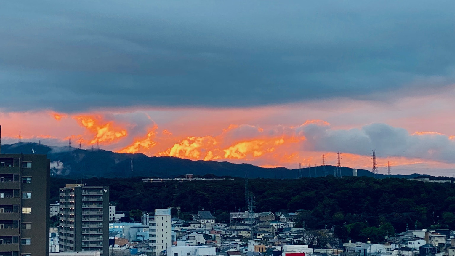 산 뒤의 일몰이 있는 도시 풍경