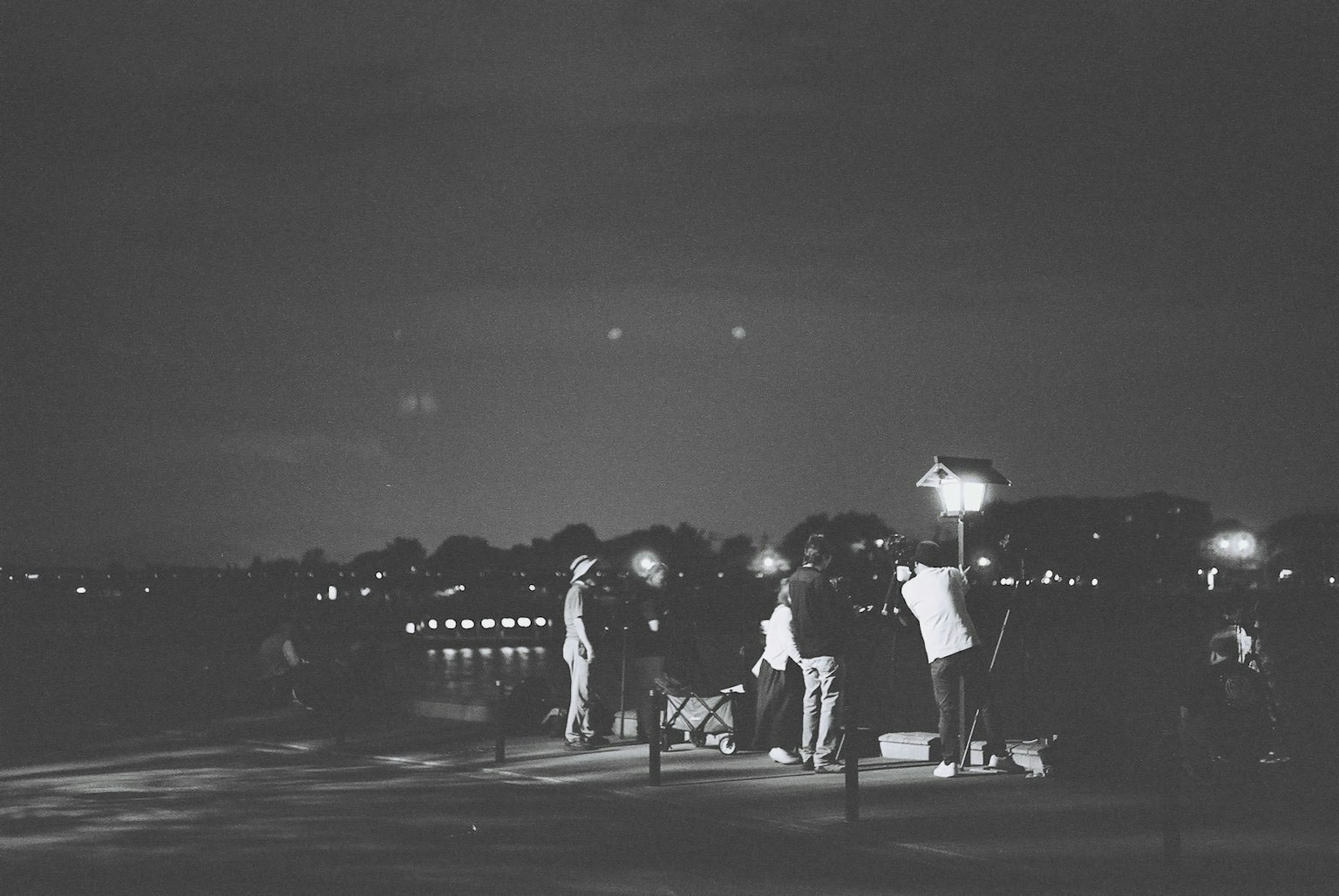 夜の公園で人々が光を持っているシーン