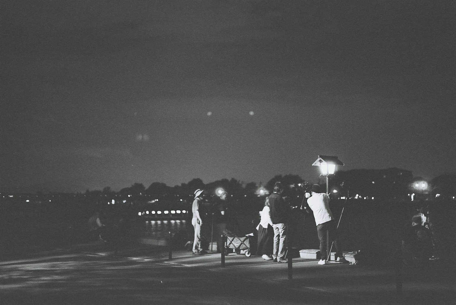 Menschen halten Lichter in einem Park bei Nacht