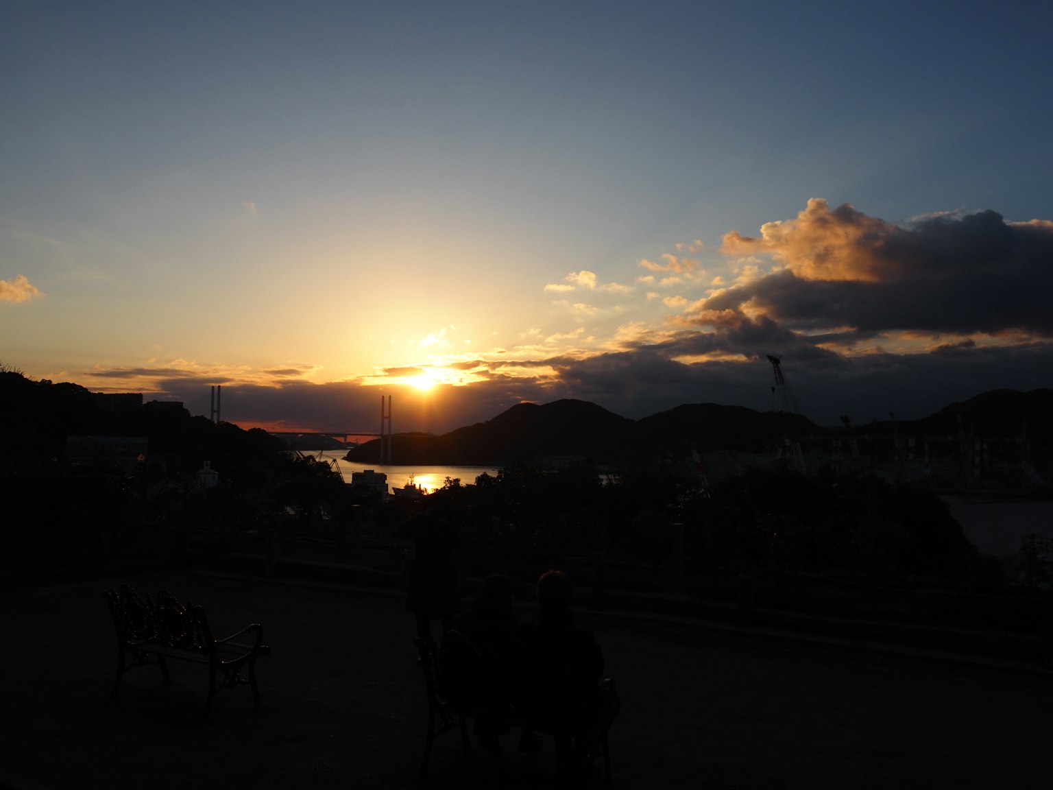 海岸日落的美丽景色，背景中有山脉和云朵