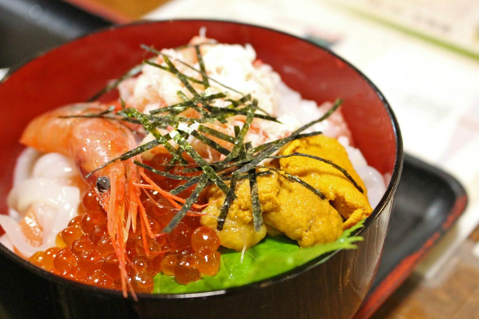 Eine Schüssel mit Meeresfrüchte-Domburi mit frischen Meeresfrüchten garniert mit Nori