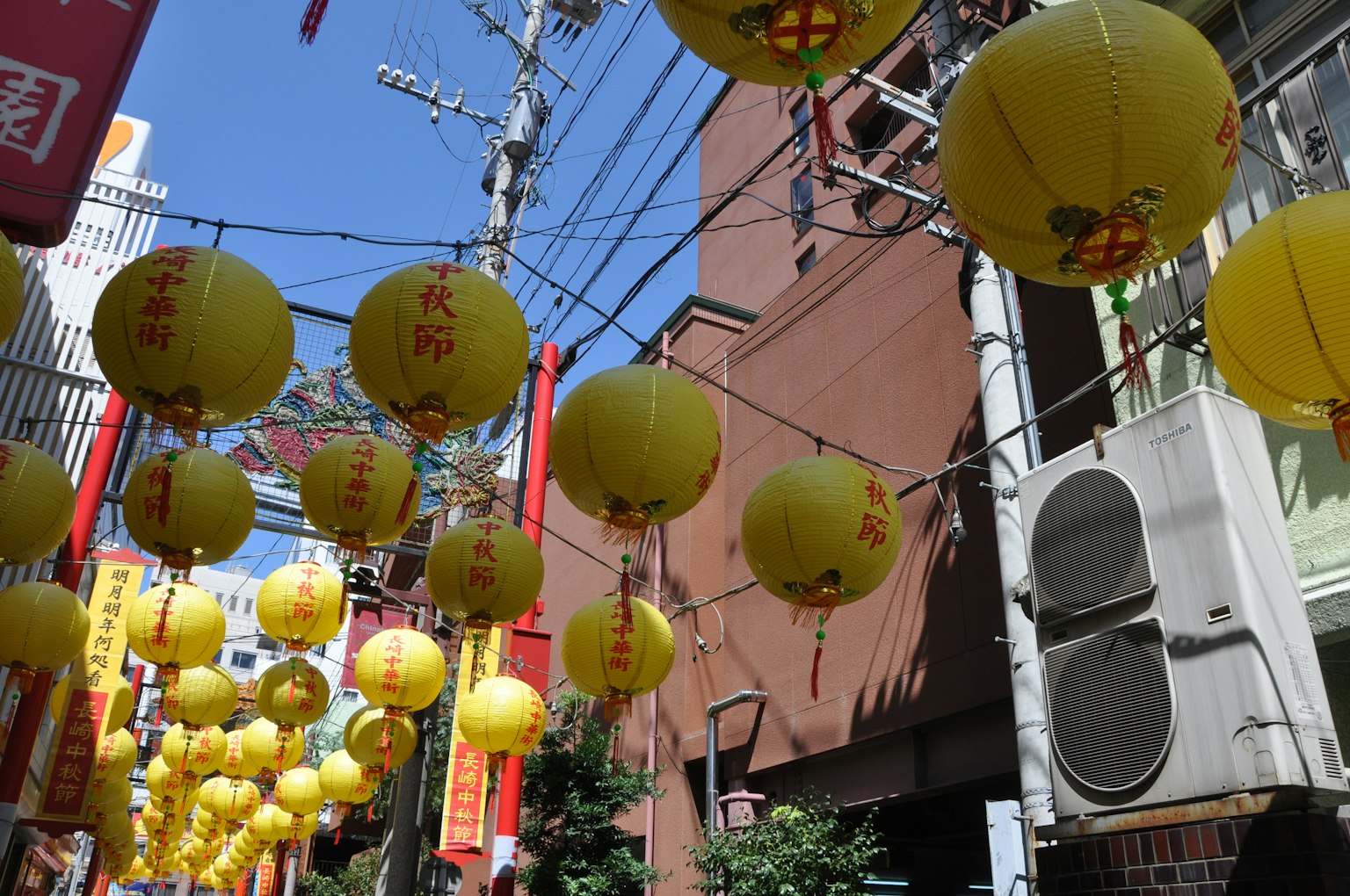 街道上掛著黃色燈籠，藍天清澈