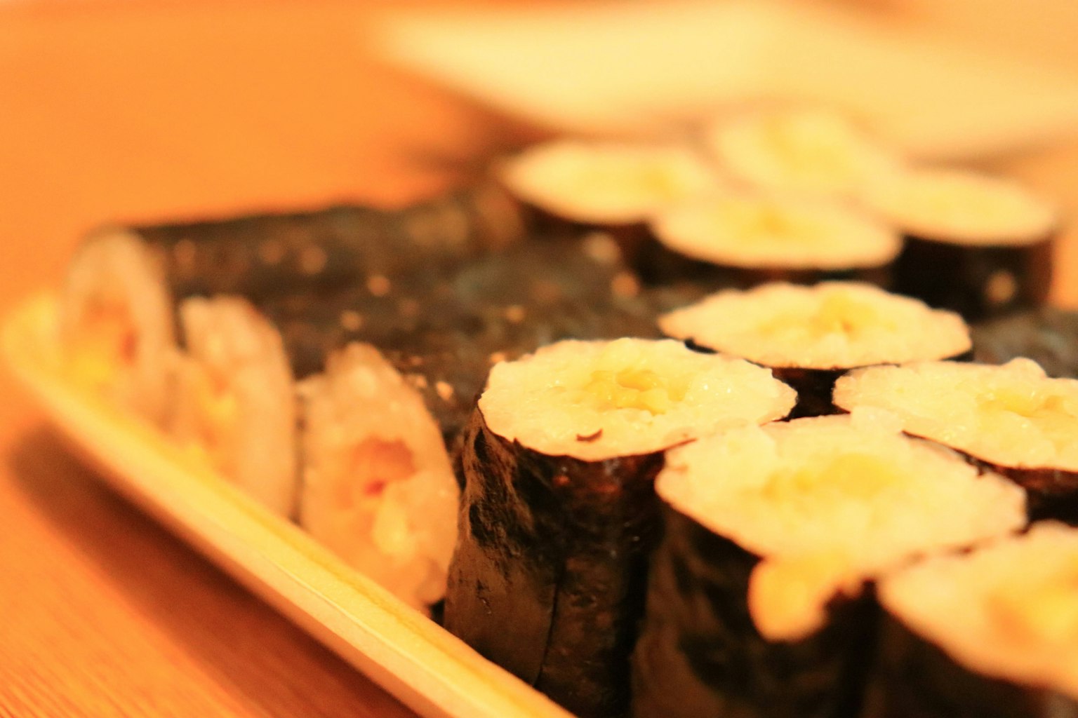 Một đĩa sushi ngon được sắp xếp trên đĩa gỗ