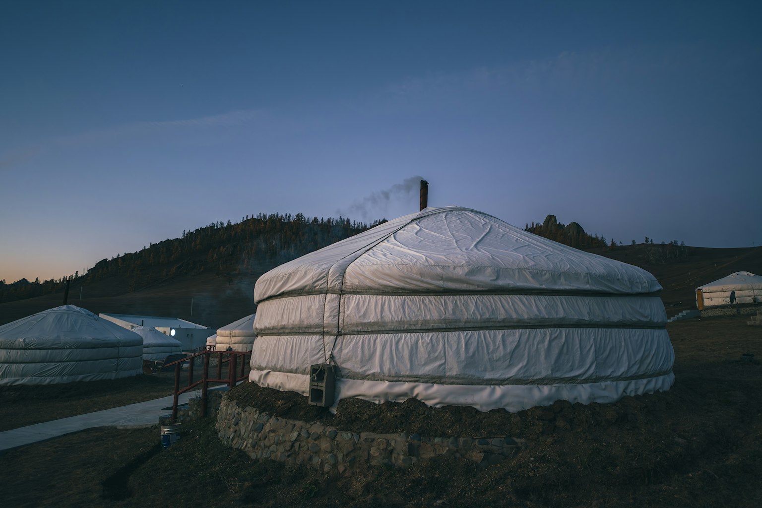 Ger in Mongolia al crepuscolo con montagne sullo sfondo
