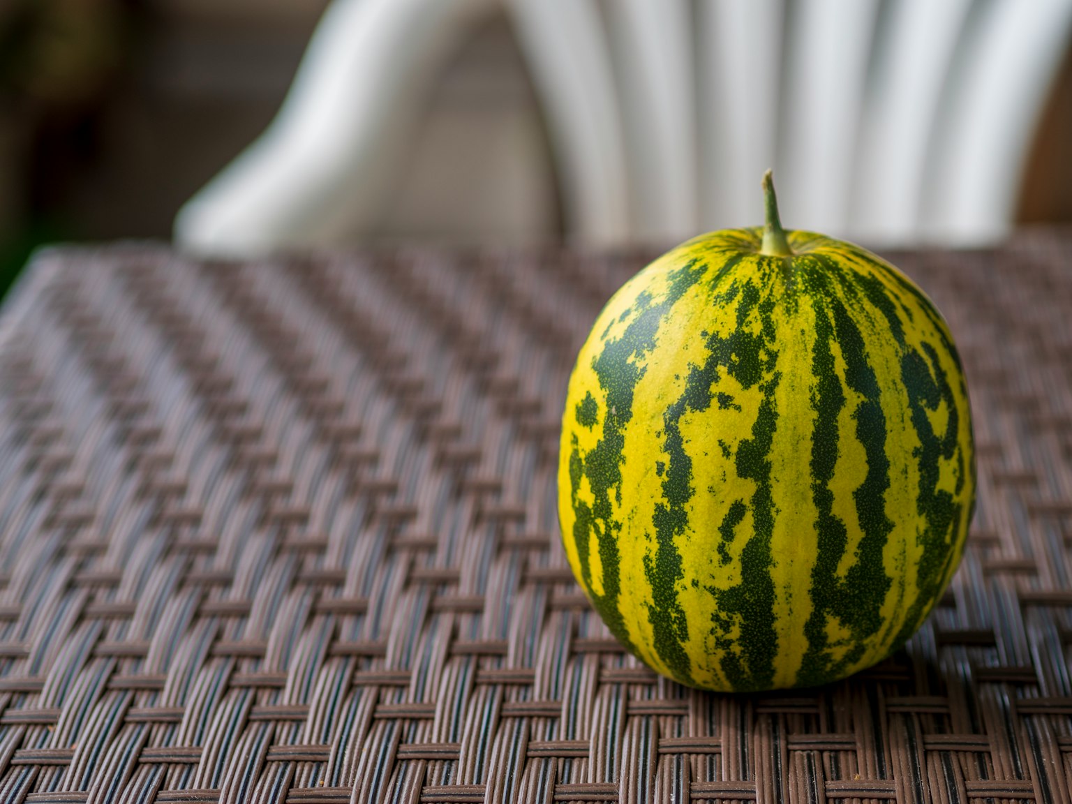 Eine grün-gelbe gestreifte Wassermelone auf einem Tisch