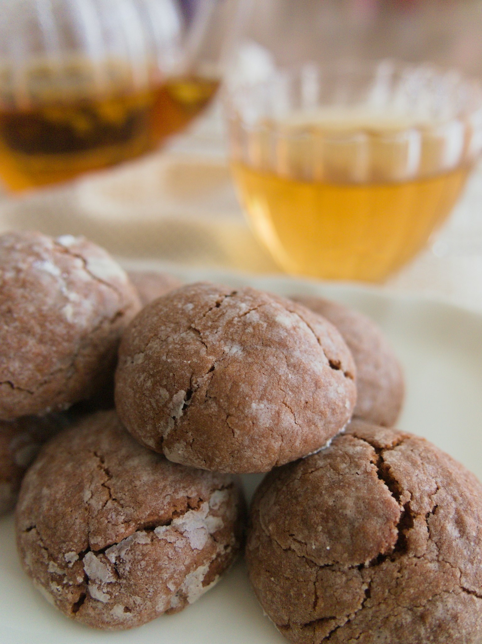 Piring kue cokelat dengan gelas minuman amber di latar belakang